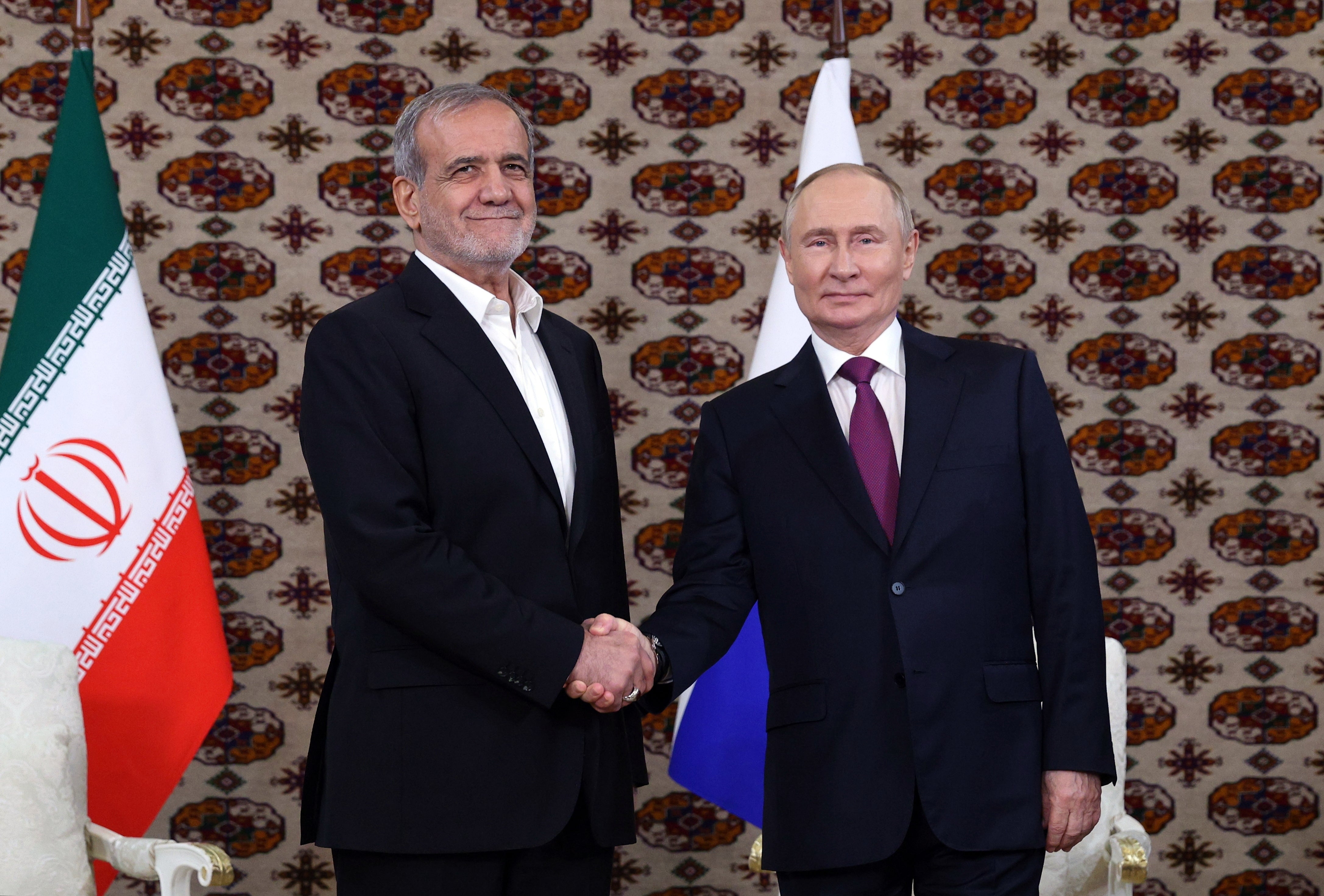 Iranian president Masoud Pezeshkian (L) attends a meeting with Russian leader Vladimir Putin (R), in Ashgabat, Turkmenistan