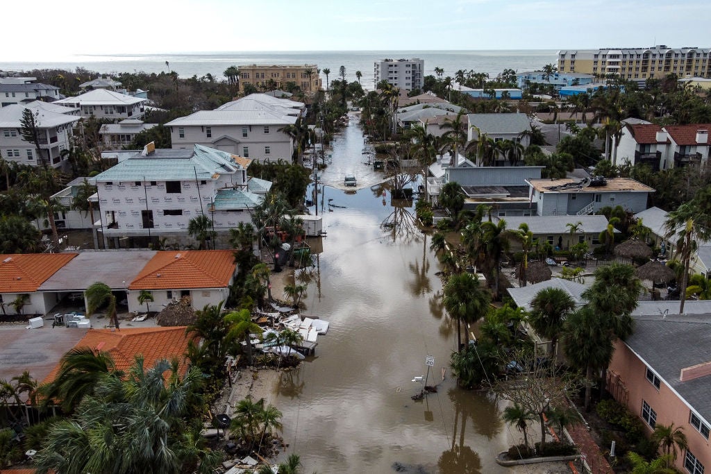 In A vehicle drives though a flooded street after Hurricane Milton, in Siesta Key, Florida