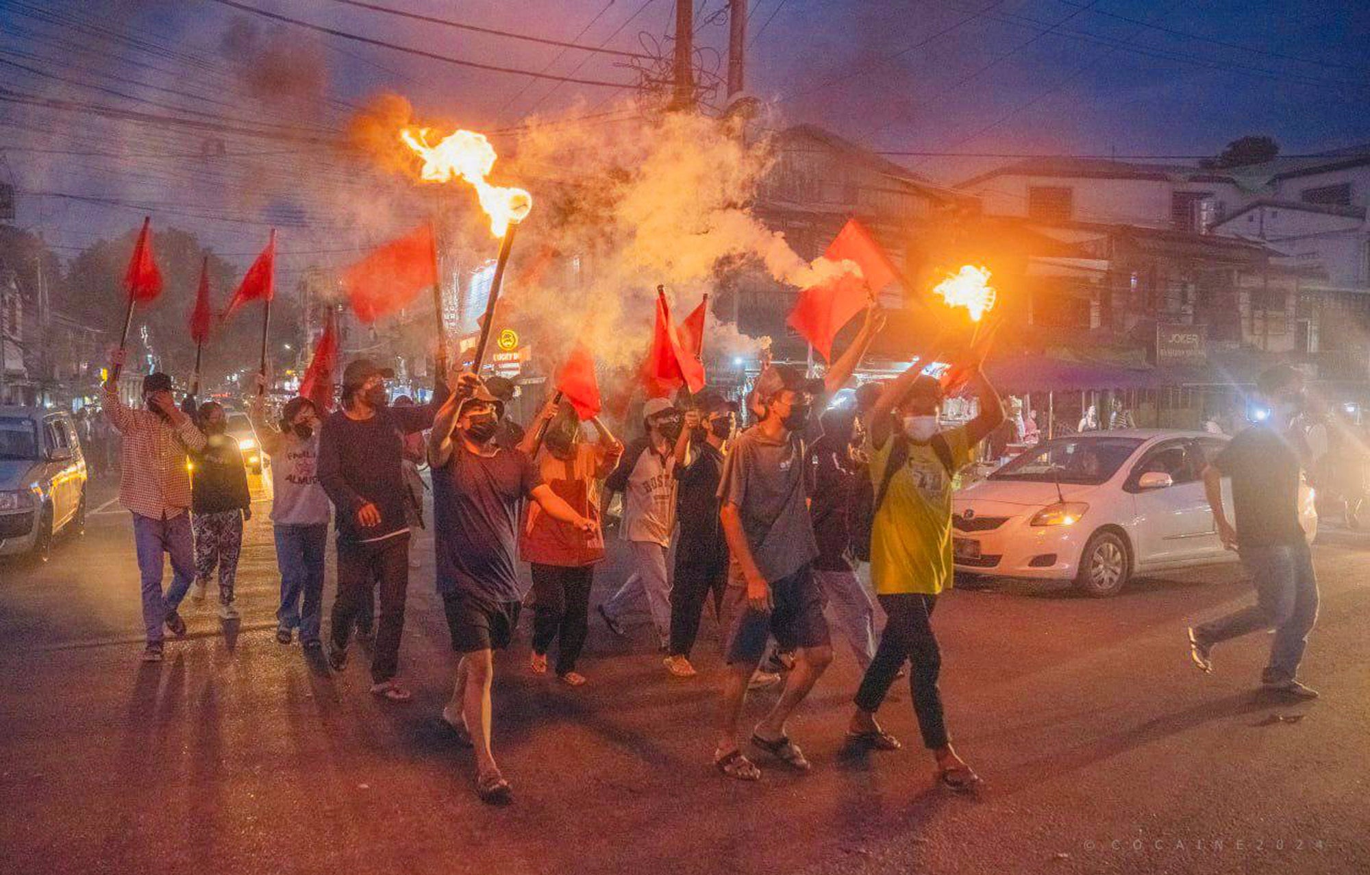 Pro-democracy protesters hold torches and flags during a flash mob rally to protest against Myanmar's military-government in Yangon