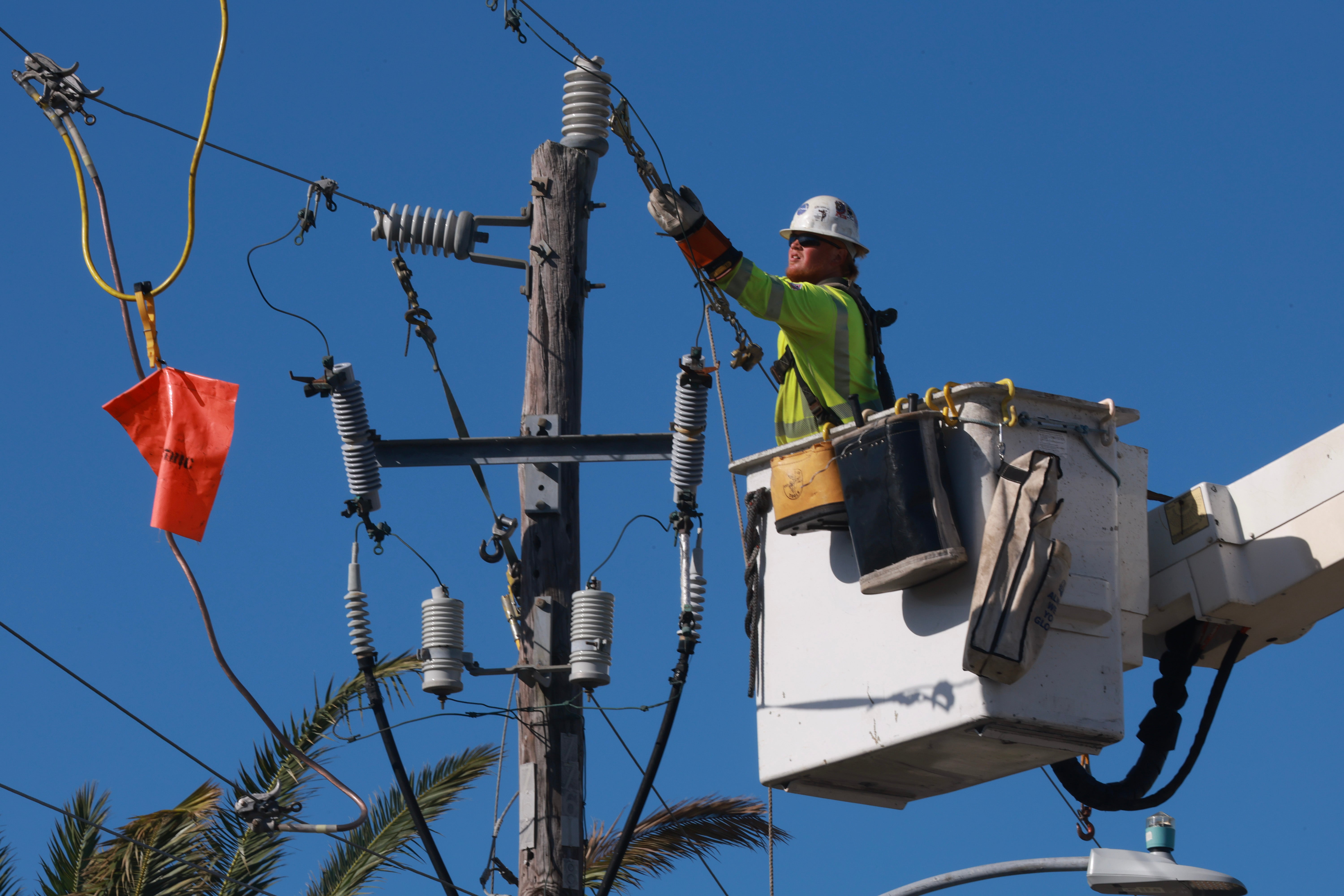 A lineman repairs power lines after Hurricane Milton passed through the area on October 12, 2024, in Englewood