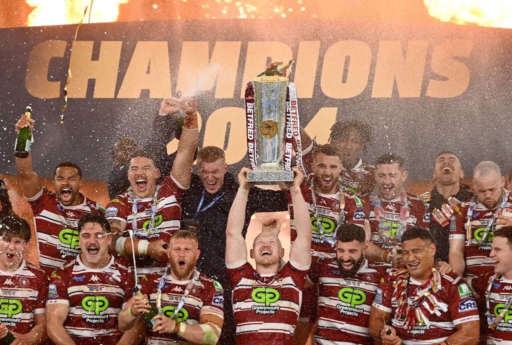 Liam Farrell of Wigan Warriors lifts the Super League Trophy