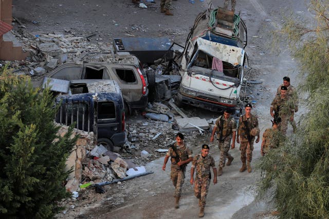 Lebanese army soldiers walk by destroyed cars at the site where an Israeli airstrike hit a building, in Barja village, south of Beirut (Mohammed Zaatari/AP)