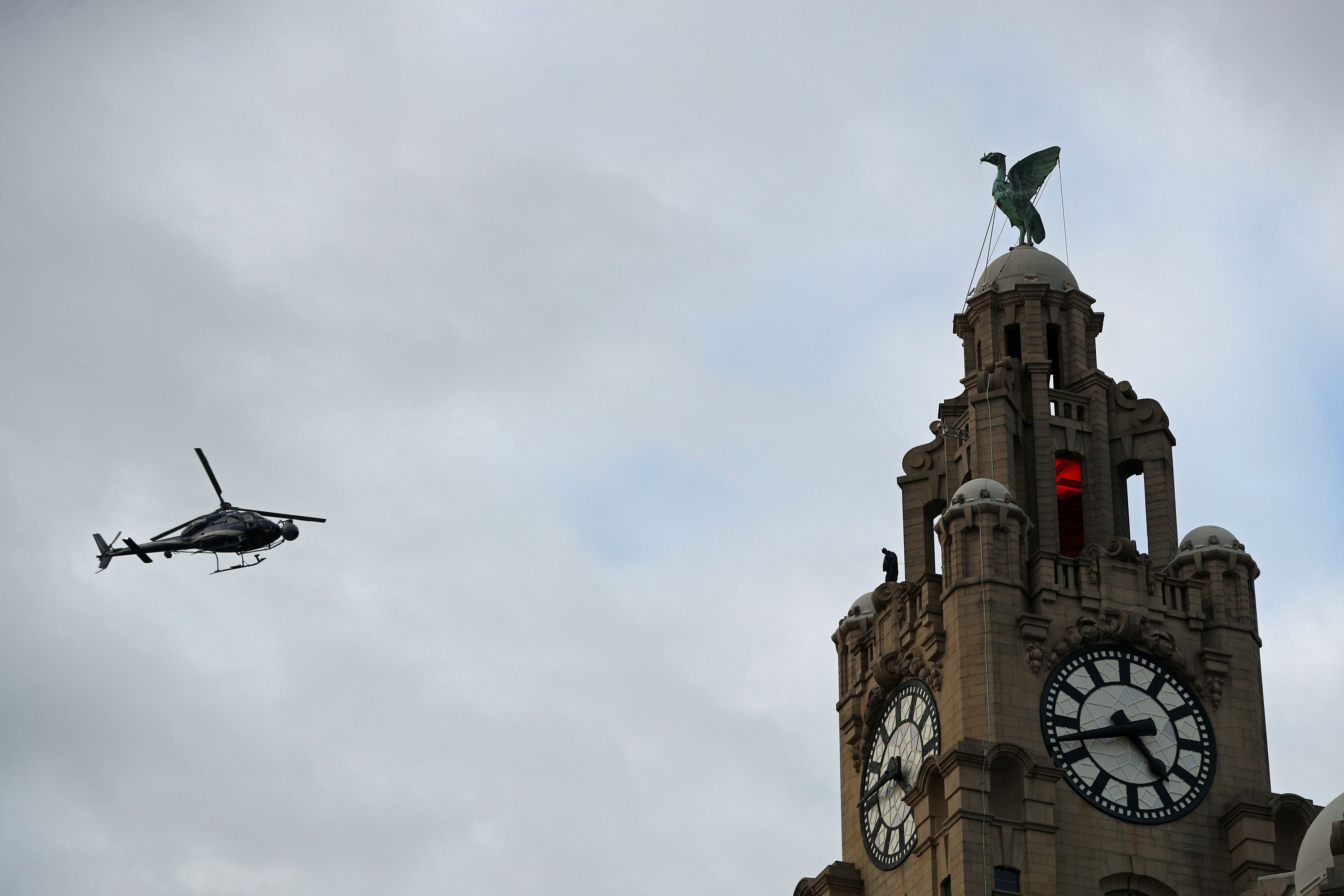 A helicopter and a stuntman on top of The Royal Liver Building in Liverpool during filming of The Batman (Peter Byrne/PA)