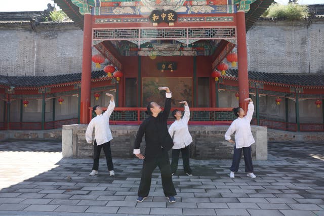 <p>Deng Jiayi (front) teaches baduanjin at Baiyun Temple in Beijing</p>