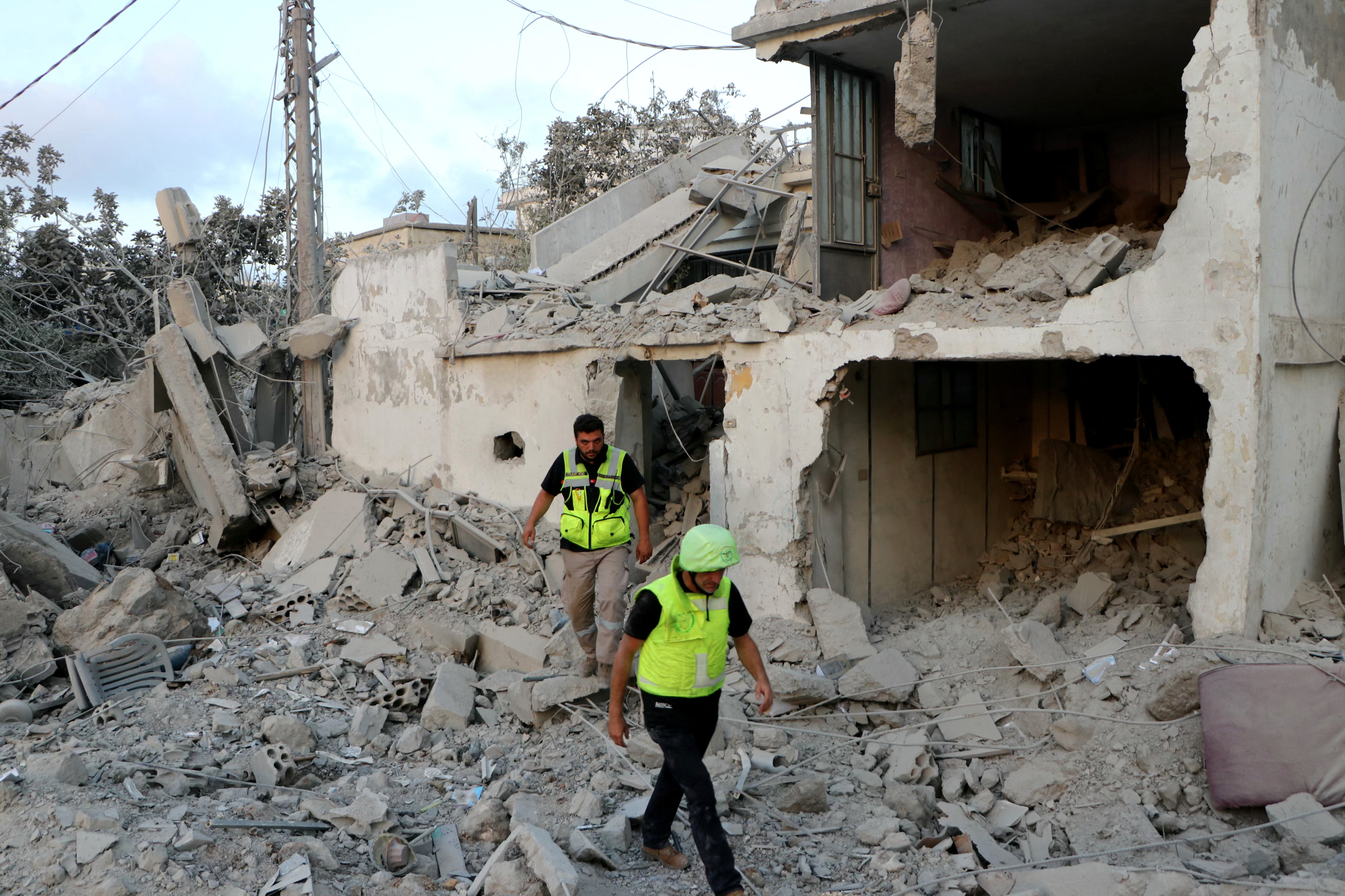 Rescuers inspect the damage at the site of an Israeli airstrike