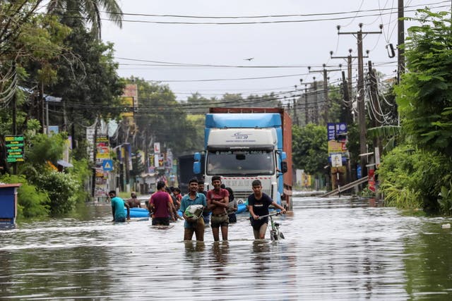 <p>People wade through a flooded road after heavy rainfall in Colombo, Sri Lanka </p>