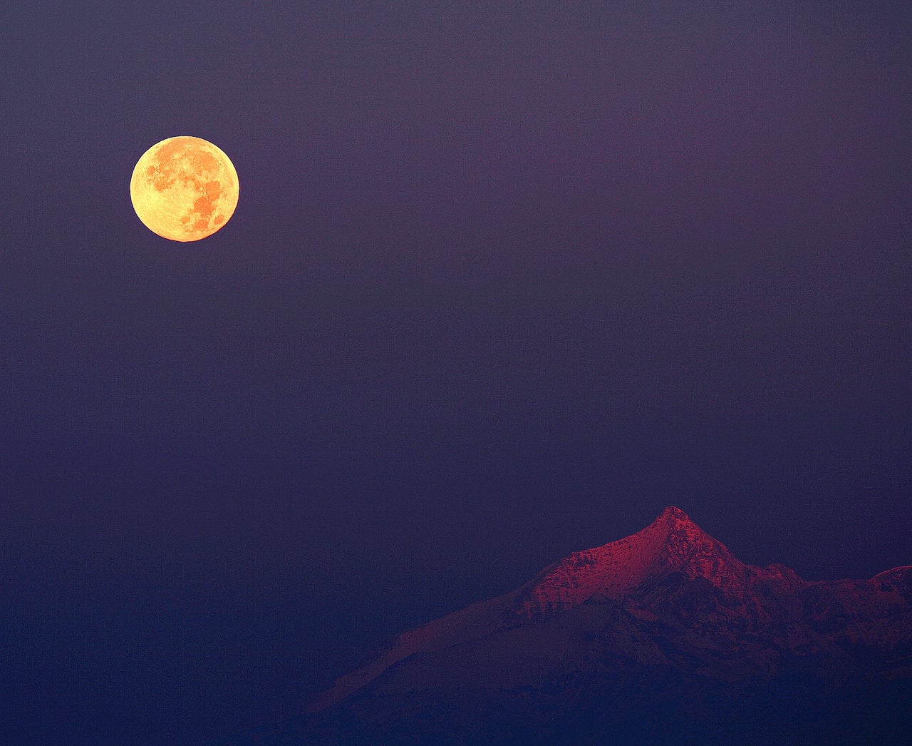 The Hunter’s moon rises next to the Swiss Alps. The moon will be at peak illumination in the US early Thursday morning