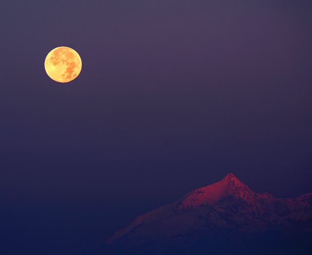 <p>The Hunter’s moon rises next to the Swiss Alps. The moon will be at peak illumination in the US early Thursday morning</p>