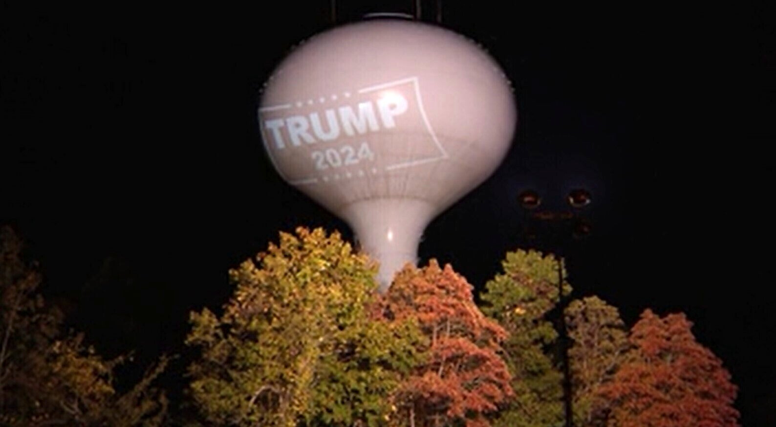 A former President Donald Trump campaign endorsement projected on a water tower in Hanson, Mass. (WCVB-TV via AP)