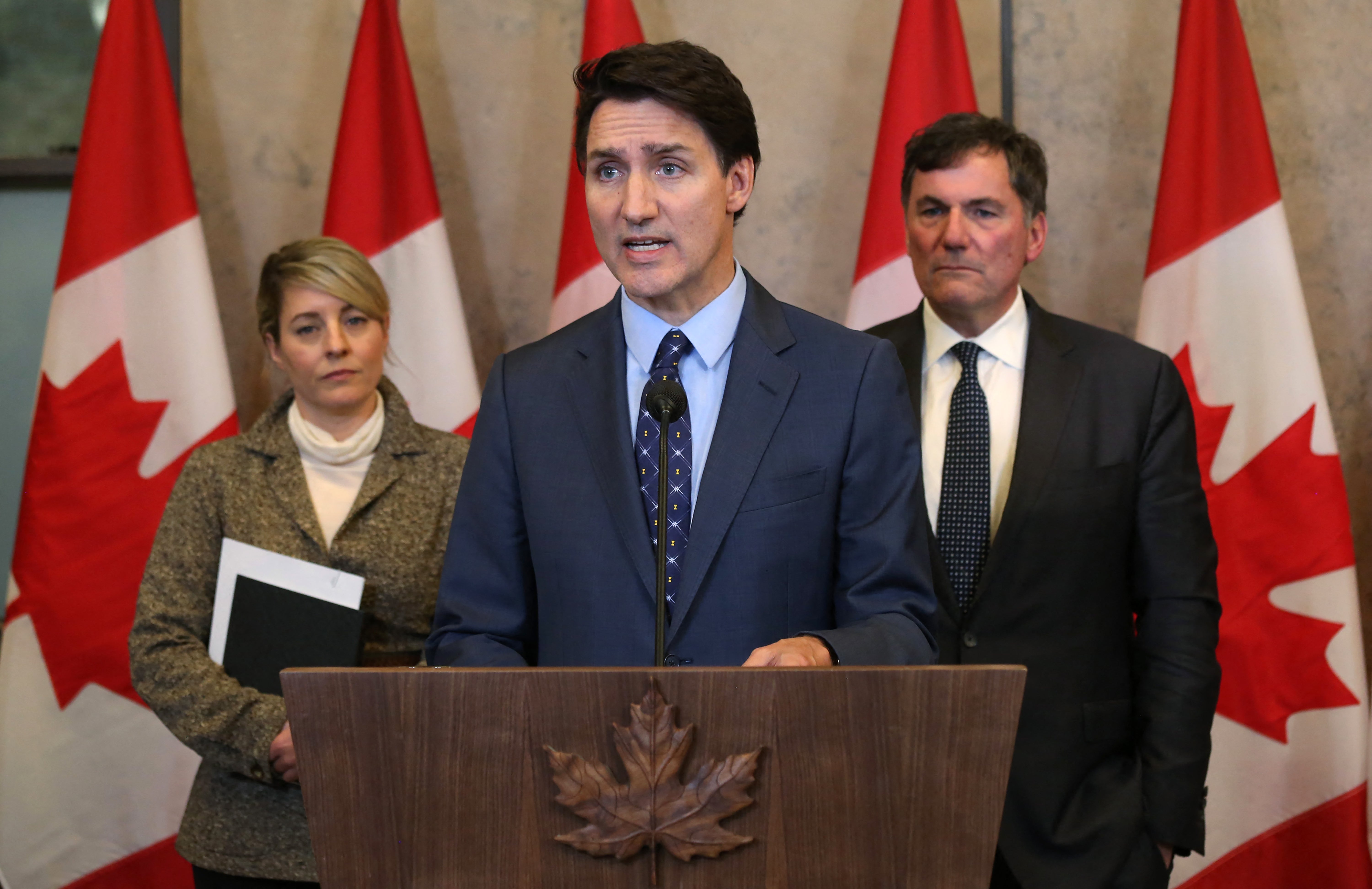 Canadian prime minister Justin Trudeau, with Foreign Minister Malanie Joly (L) and Public Safety Minister Dominic LeBlanc speaks during a press conference on 14 October 2024, on Parliament Hill in Ottawa