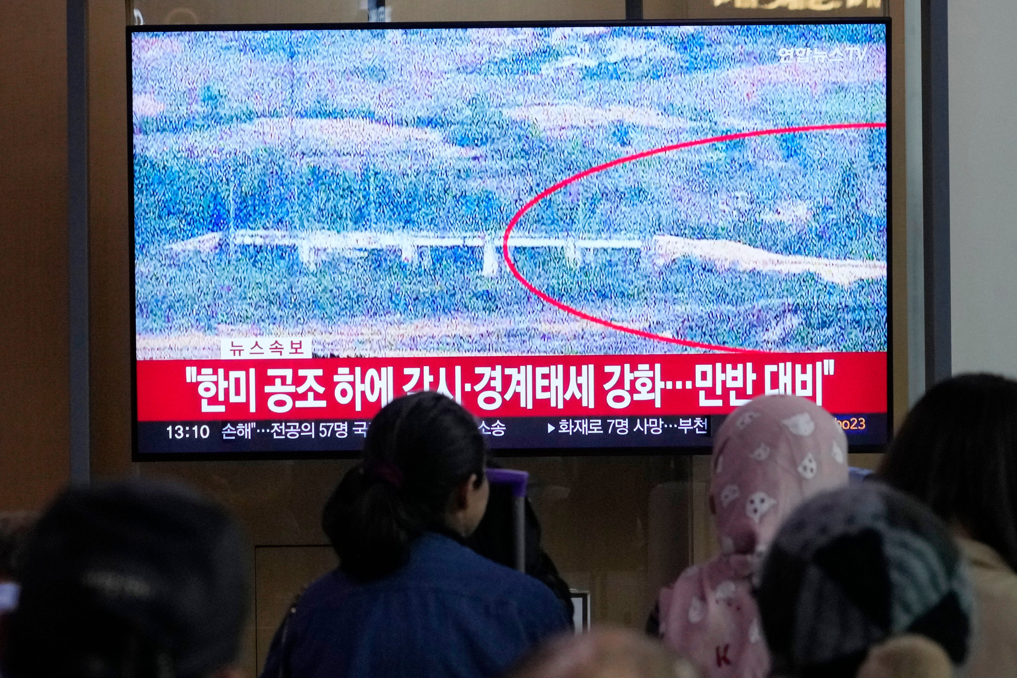 South Koreans watch a news report about North Korea blowing up sections of inter-Korea roads on a TV screen at the Seoul railway station on 15 October 2024