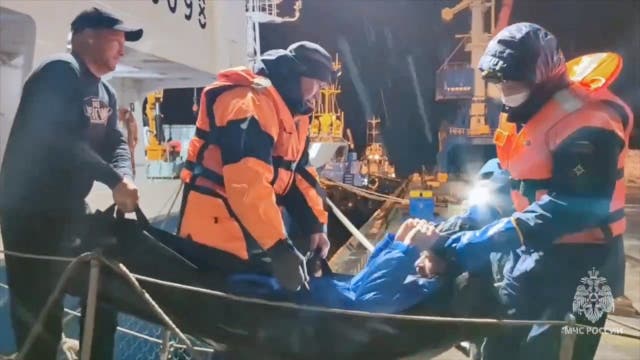 <p>Rescuers leave a vessel while carrying a man, who was reportedly saved after his sailboat had drifted for 67 days in waters edging the northwestern Pacific and discovered by fishermen</p>