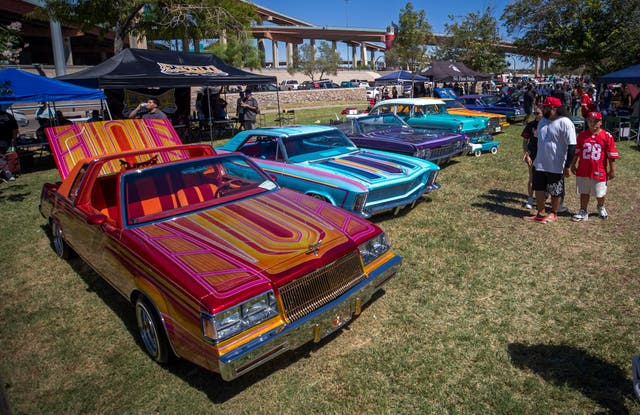 <p>A family looks at vintage cars during a lowrider exhibition for the 20th anniversary of Lincoln Park in El Paso</p>