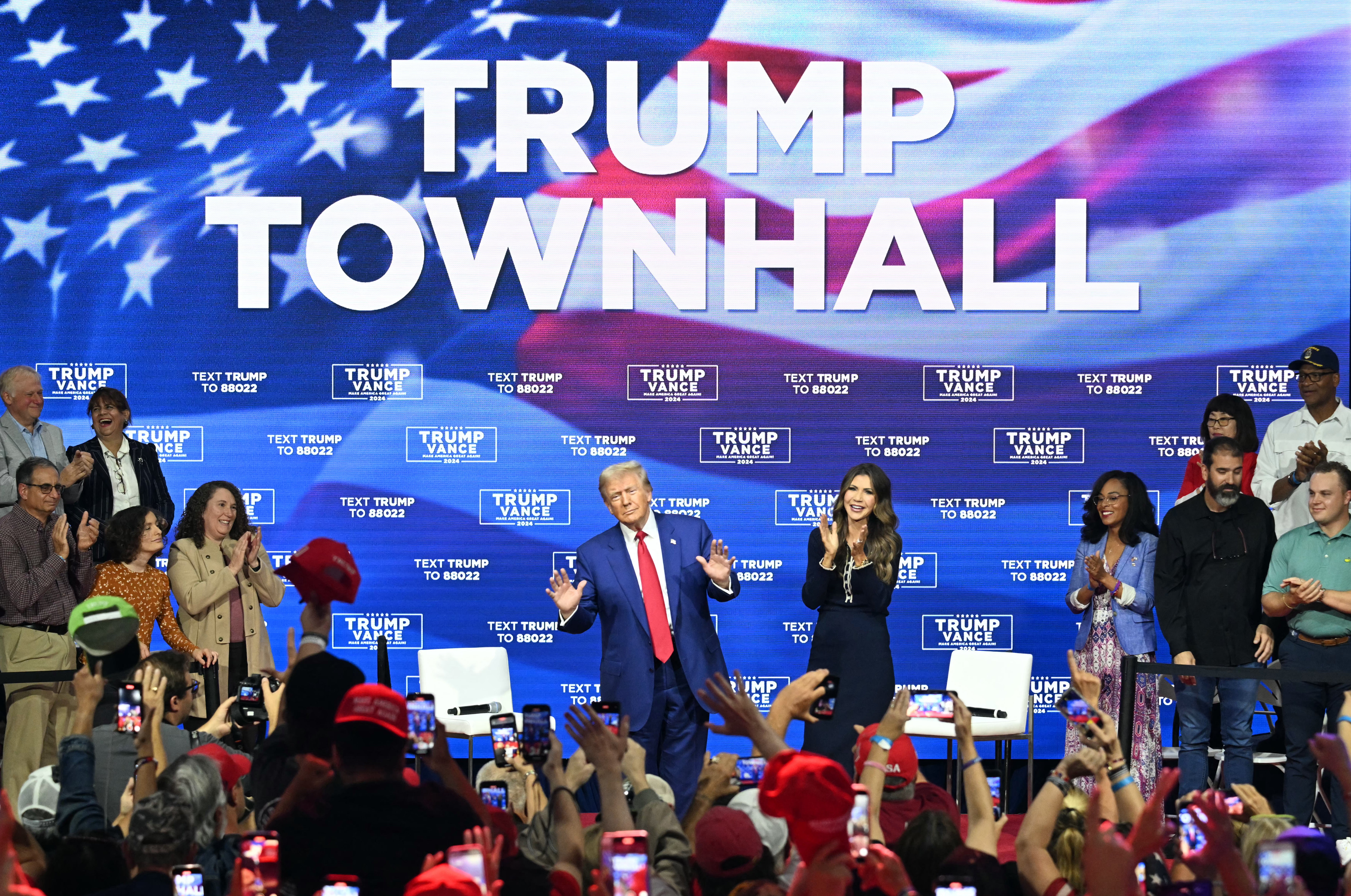 Former US President and Republican presidential candidate Donald Trump with moderator and South Dakota Governor Kristi Noem (r) at the town hall in Oaks, Pennsylvania, on October 14, 2024