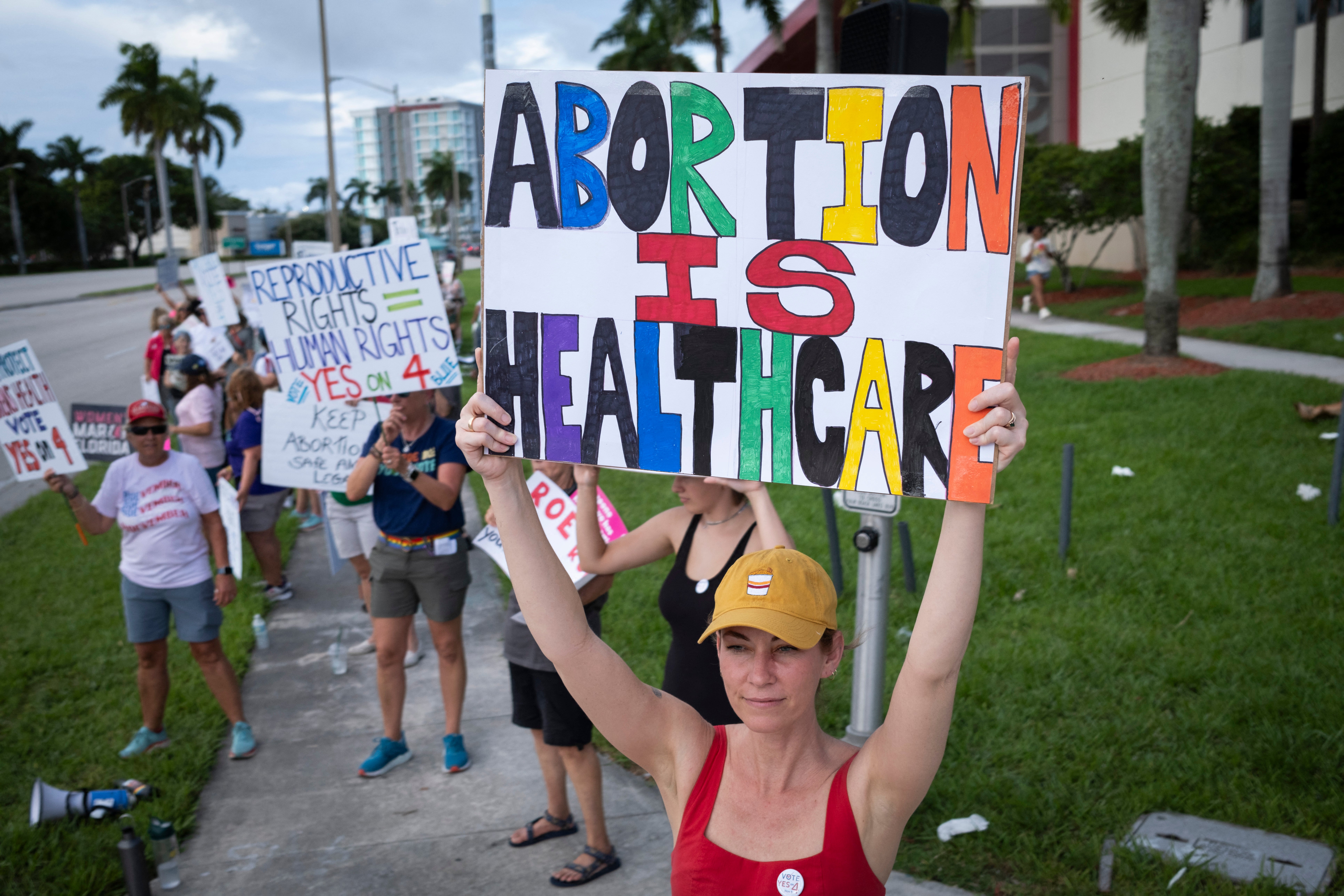 People hold up signs during a pro-abortion rights rally on the second anniversary of the Supreme Court ruling to overturn Roe v. Wade, in West Palm Beach, Florida, on June 24, 2024.