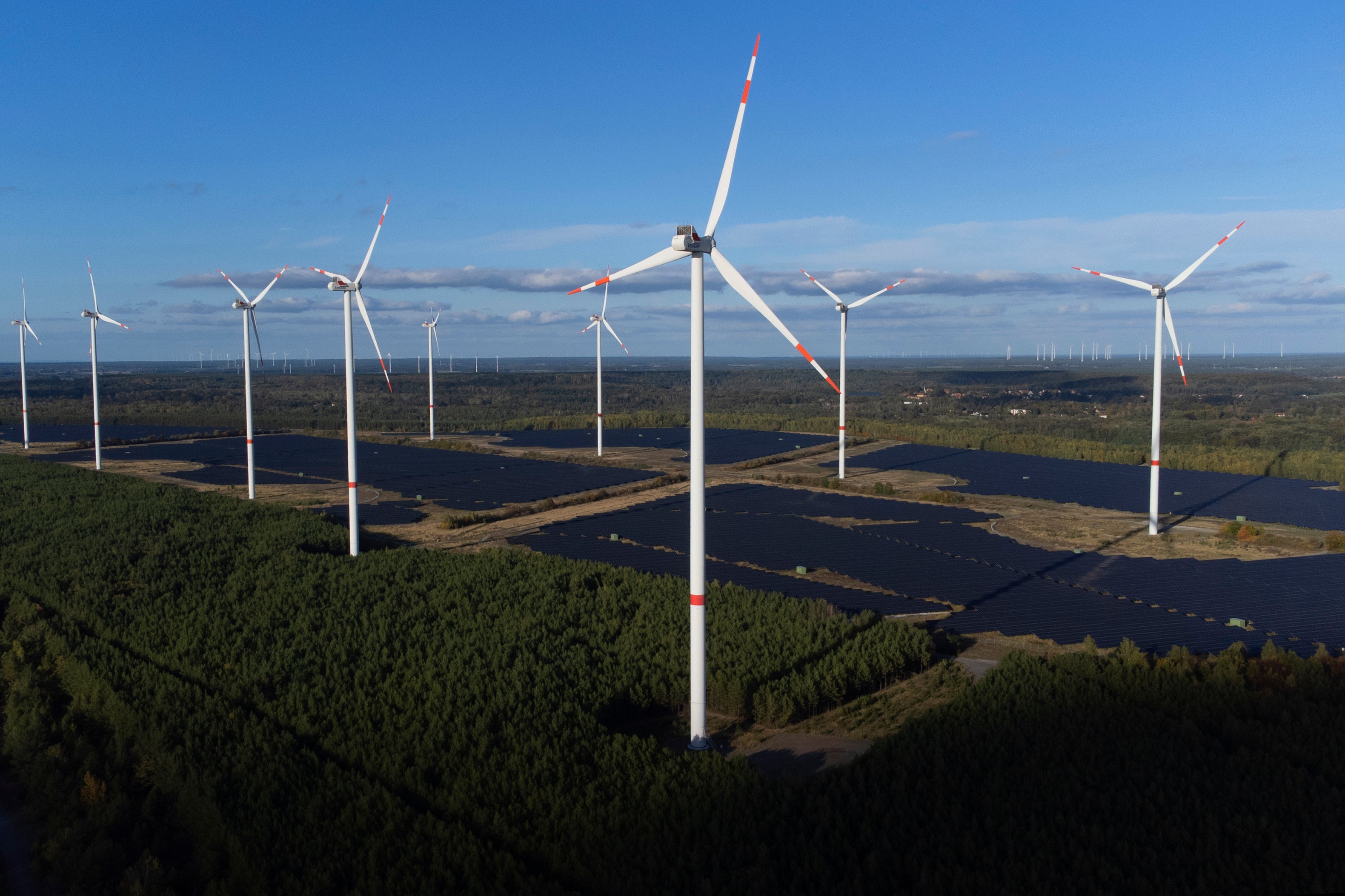<p>Wind turbines operate at the Klettwitz Nord solar energy park near Klettwitz in Germany </p>