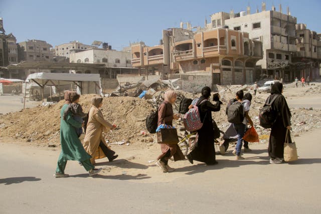 <p>Palestinians carry their belongings as they flee areas north of Gaza City on 12 October 2024 </p>