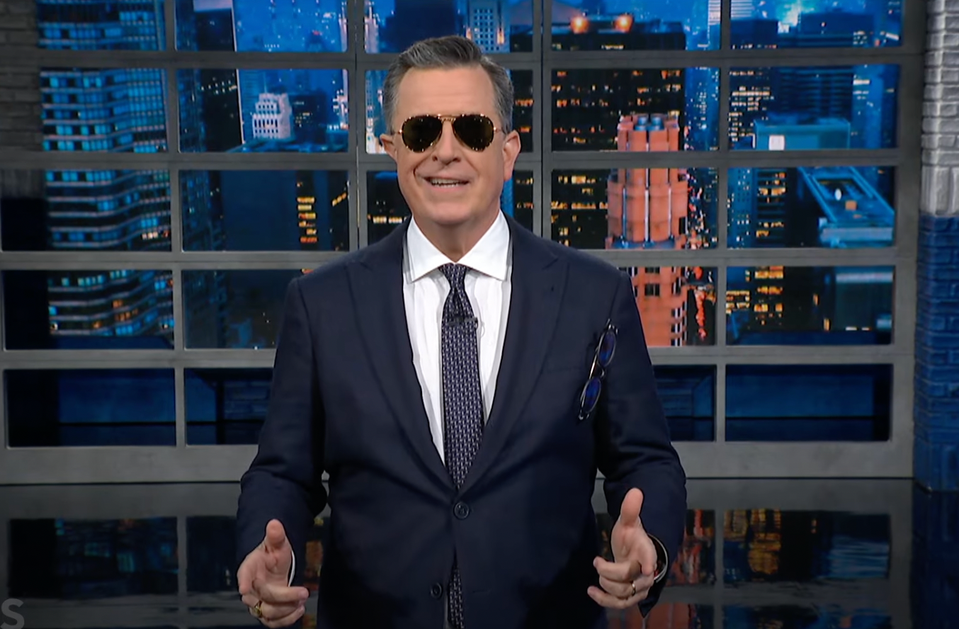 Stephen Colbert wears aviator sunglasses as he portrays President Joe Biden on “The Late Show with Stephen Colbert.”