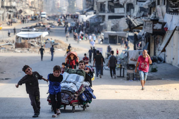 Palestinians carry their belongings as they flee areas north of Gaza City on October 12, 2024