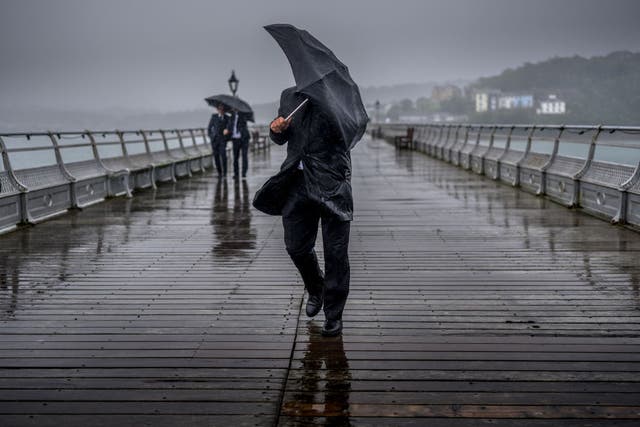 <p>People battle against high winds and driving rain on the historic Garth Pier in Bangor earlier this year </p>