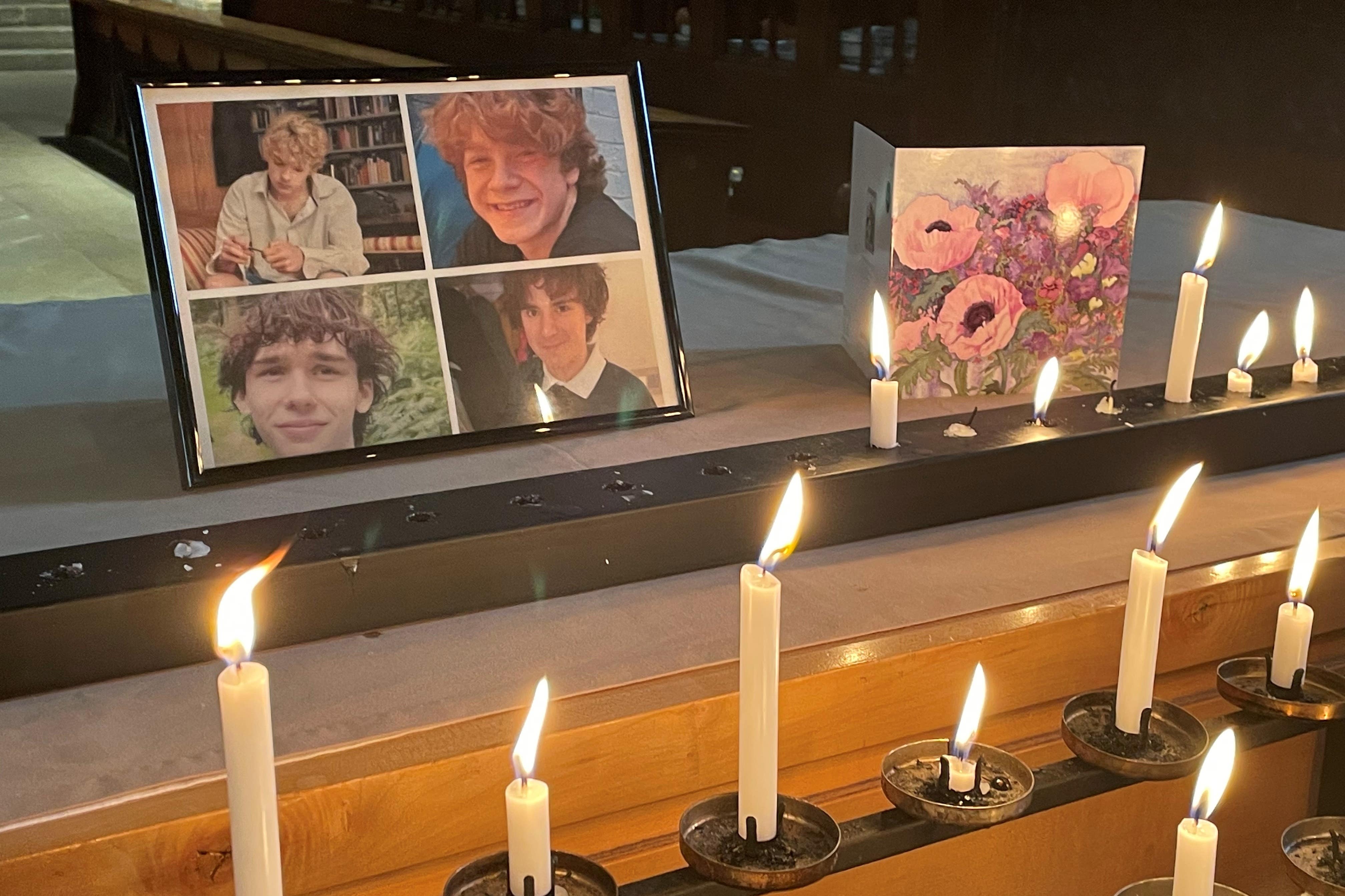 Photos of the four friends surrounded by candles and a sympathy card inside Shrewsbury Abbey