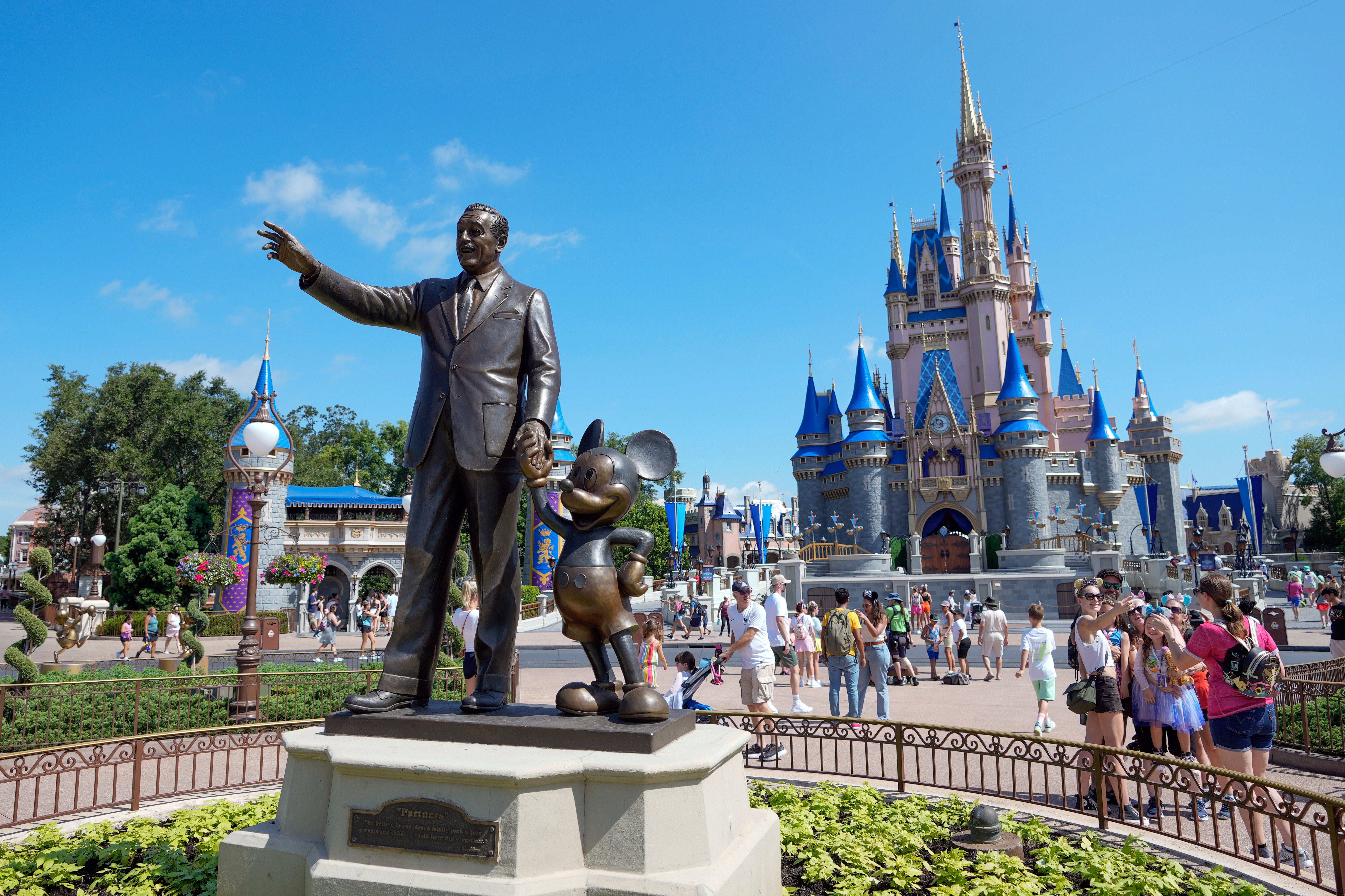 Guests pass a statue of Walt Disney and Mickey Mouse in the Magic Kingdom at Walt Disney World on July 14, 2023,