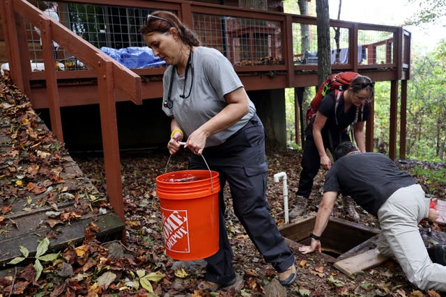 <p>Nurse practitioner Jen Felter, Dr. Khristina Meissner and Dr. Pat Tucker, all volunteers, retrieve water from a well for a woman in the aftermath of Hurricane Helene flooding on October 7 in Swannanoa, North Carolina. </p>