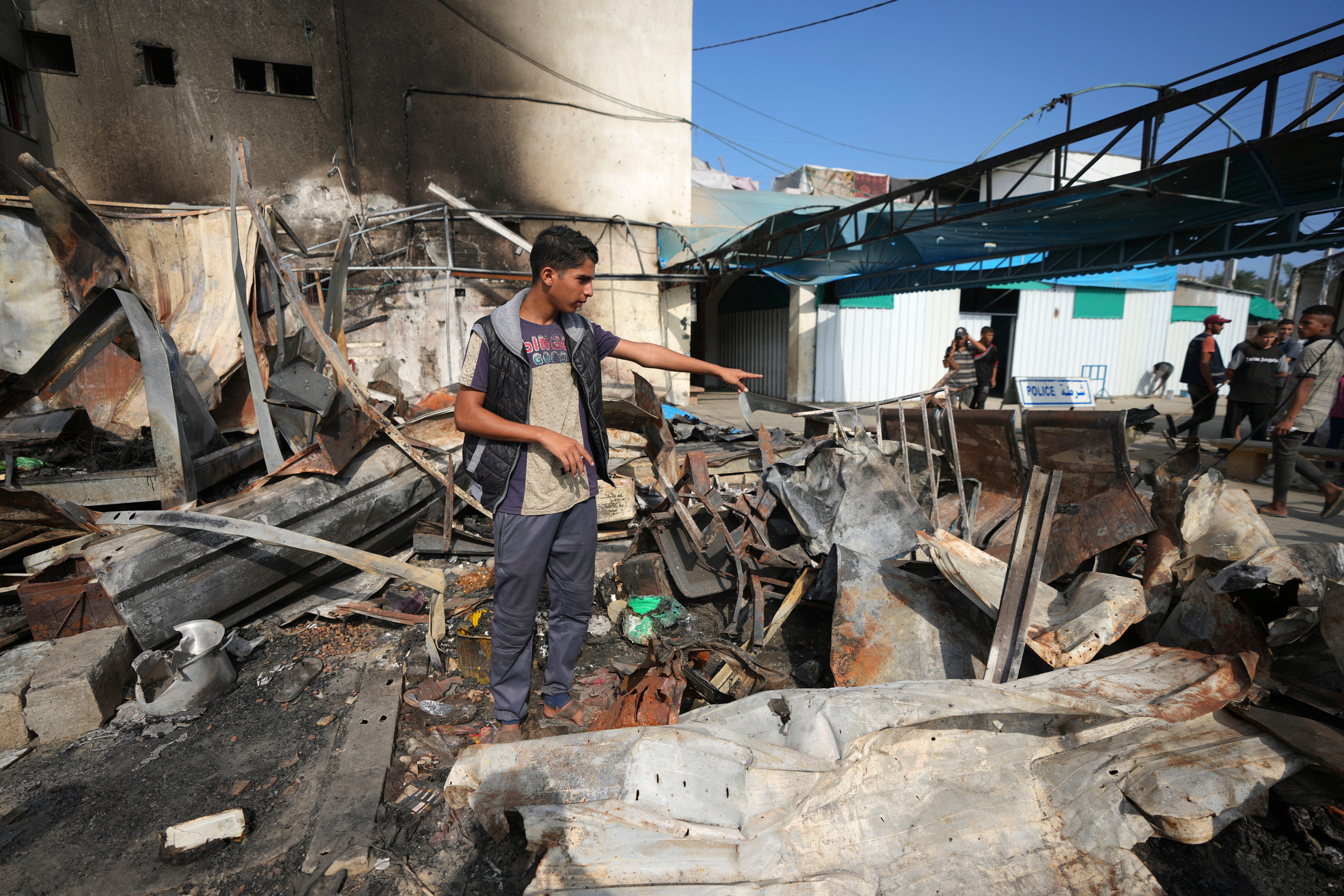 Mohamed al-Dalu gestates to the site where his brother, Shaban, was killed in a fire after an Israeli strike hit a tent area in the courtyard of Al Aqsa Martyrs hospital in Deir al-Balah, Gaza Strip, Wednesday, Oct. 16, 2024.