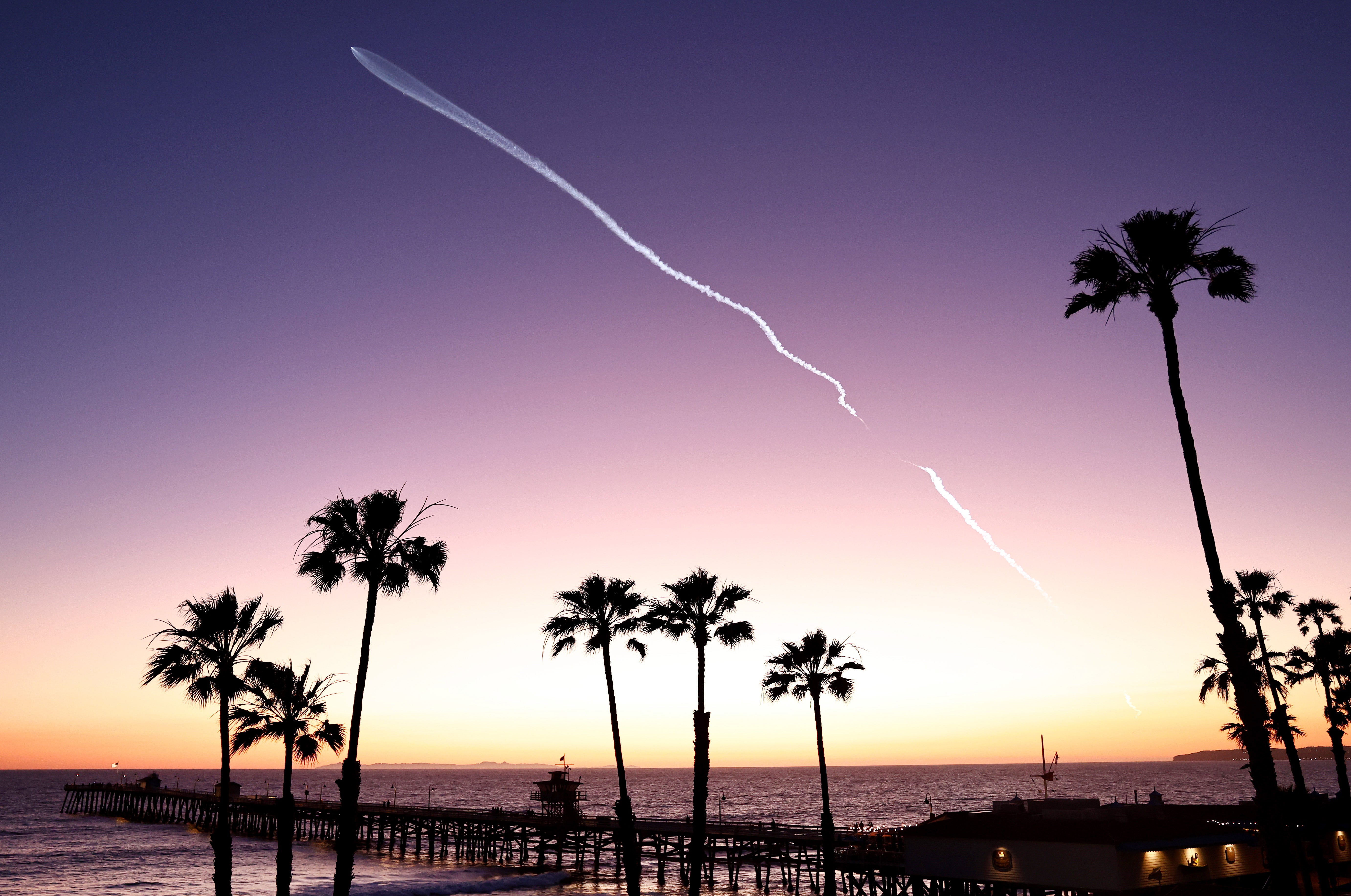 A SpaceX Falcon 9 rocket flies above the Pacific Ocean carrying a payload of 22 Starlink internet satellites into space