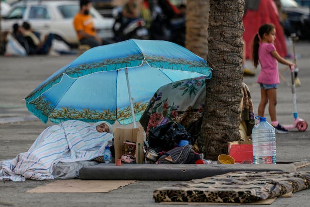 A woman sleeps on Beirut’s corniche after fleeing Israeli airstrikes in Dahiyeh, Lebanon (Bilal Hussein/AP)