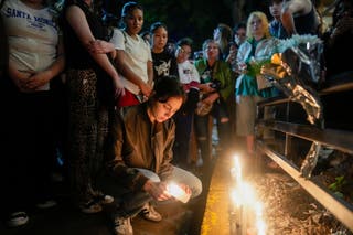 Fans light candles outside the hotel where Liam Payne died. Authorities have sent his body for an autopsy