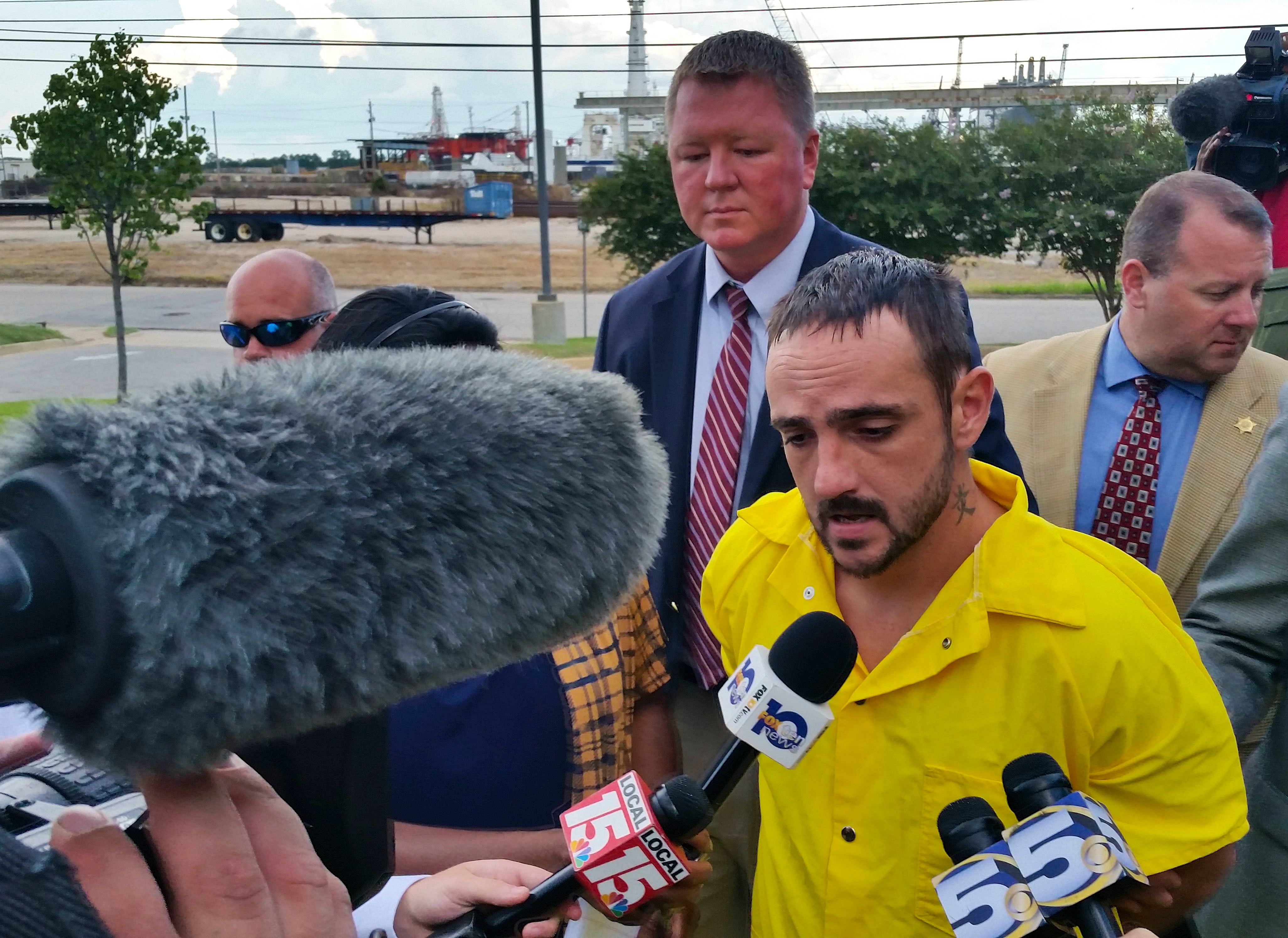 Derrick Dearman, 27, of Leakesville, Miss., center, is escorted into Mobile County Metro Jail in Mobile