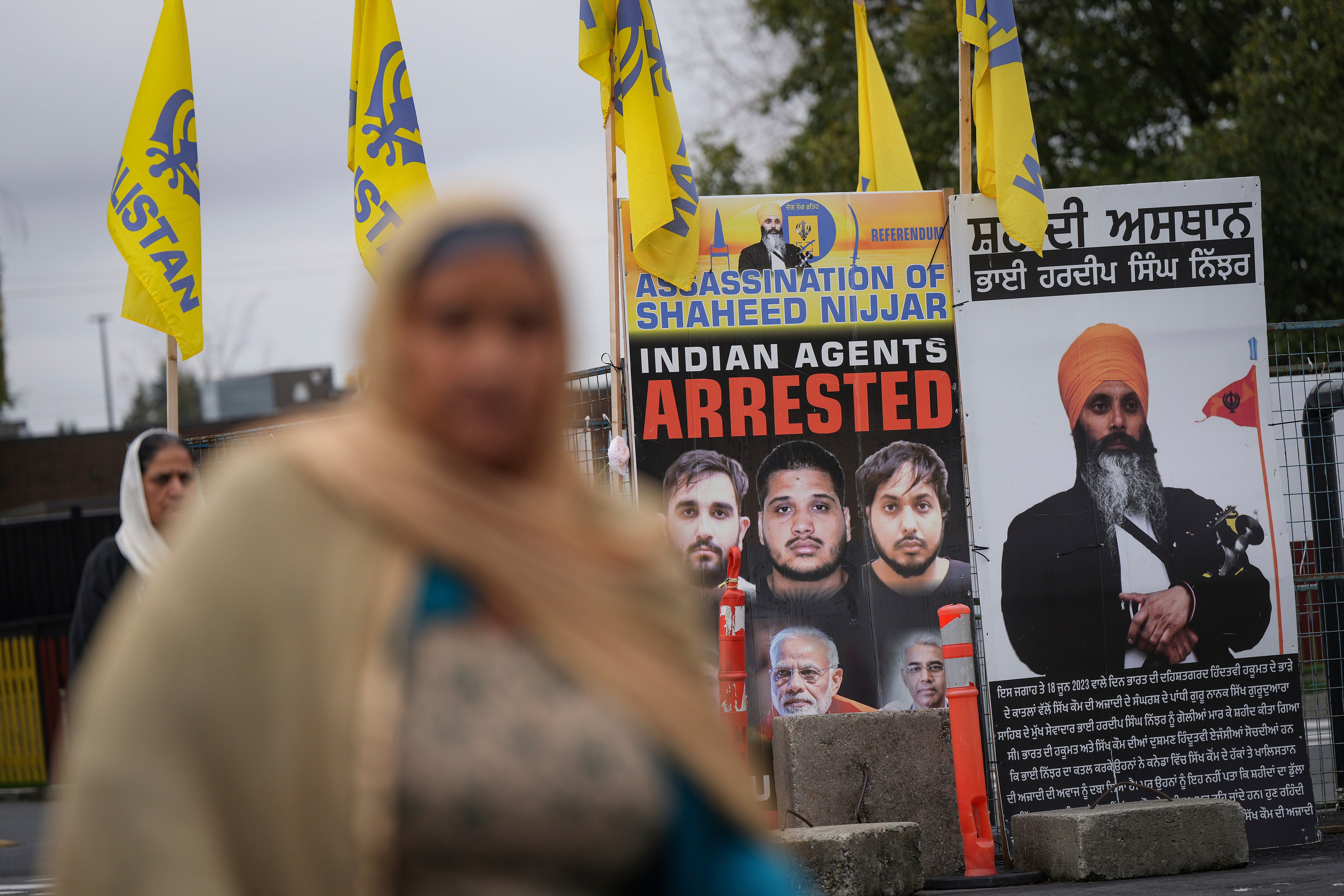 A photograph of late temple president Hardeep Singh Nijjar, back right, is displayed outside the Guru Nanak Sikh Gurdwara Sahib in Surrey