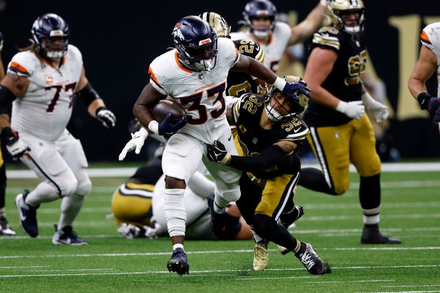 Denver Broncos running back Javonte Williams breaks a tackle by New Orleans Saints safety Tyrann Mathieu (Butch Dill/AP)