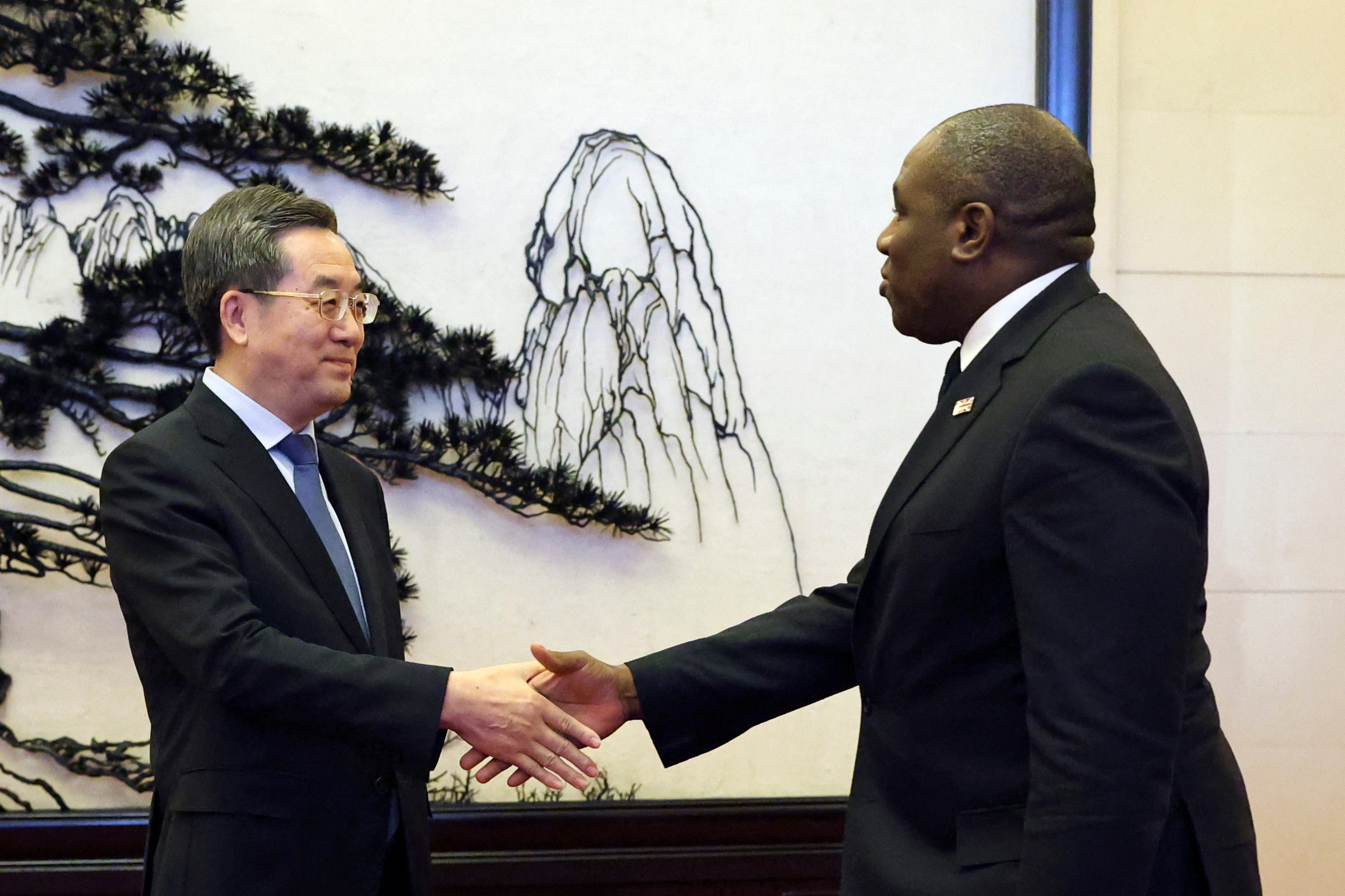 Britain's Foreign Secretary David Lammy and Chinese Vice Premier Ding Xuexiang shake hands before their meeting at the Great Hall of the People in Beijing