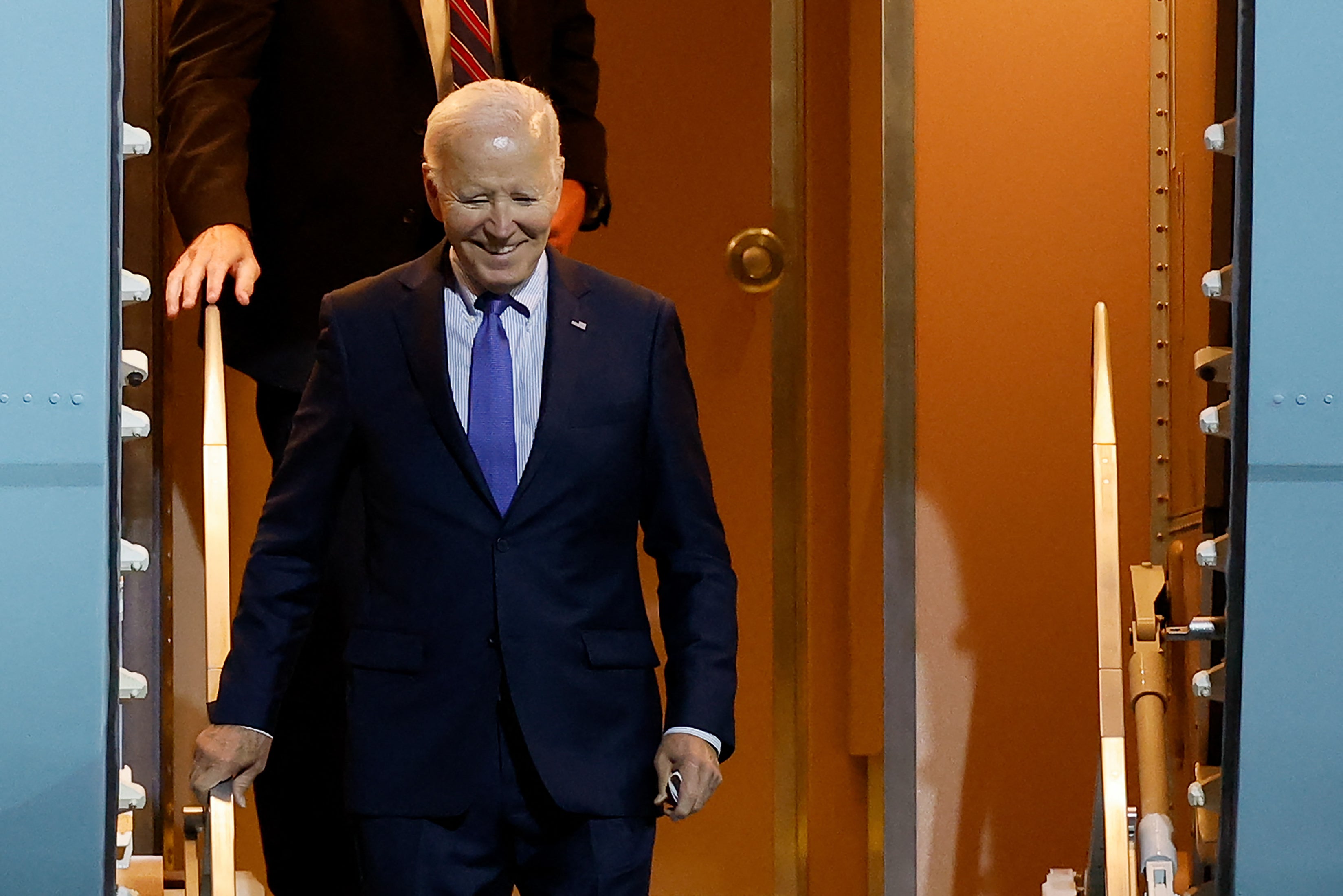 Biden smiles as he disembarks from Air Force One for a farewell visit to Germany