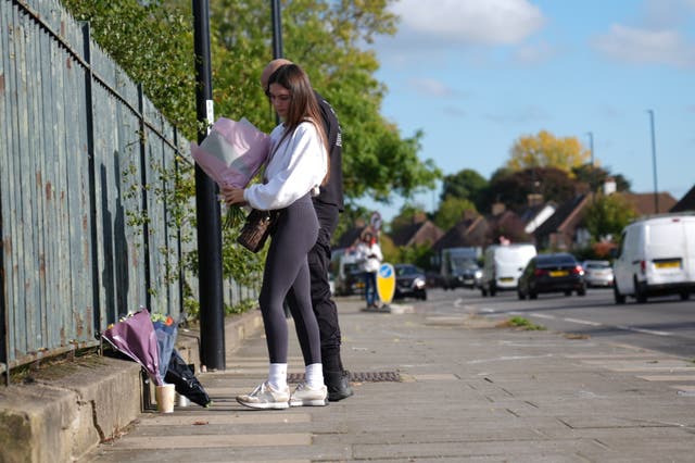 <p>People lay flowers at the scene near the A20 and Kidbrooke Park Road in Eltham</p>