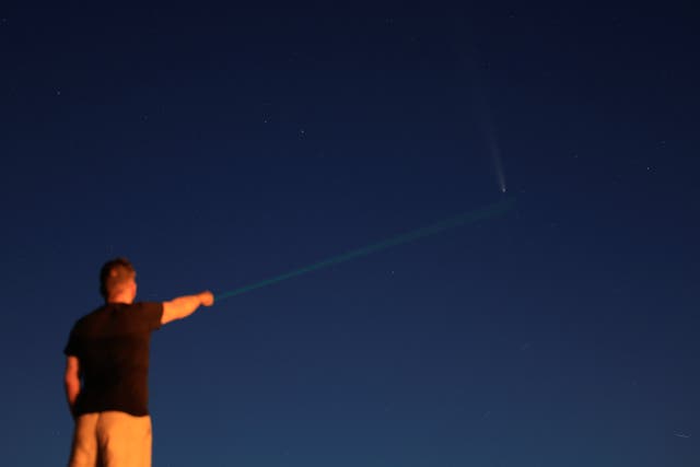 <p>A man with an astronomical laser points out the Comet C/2023 A3 (Tsuchinshan-ATLAS), known as the comet of the century, in Pico De Las Nieves on the island of Gran Canaria, Spain, October 17</p>