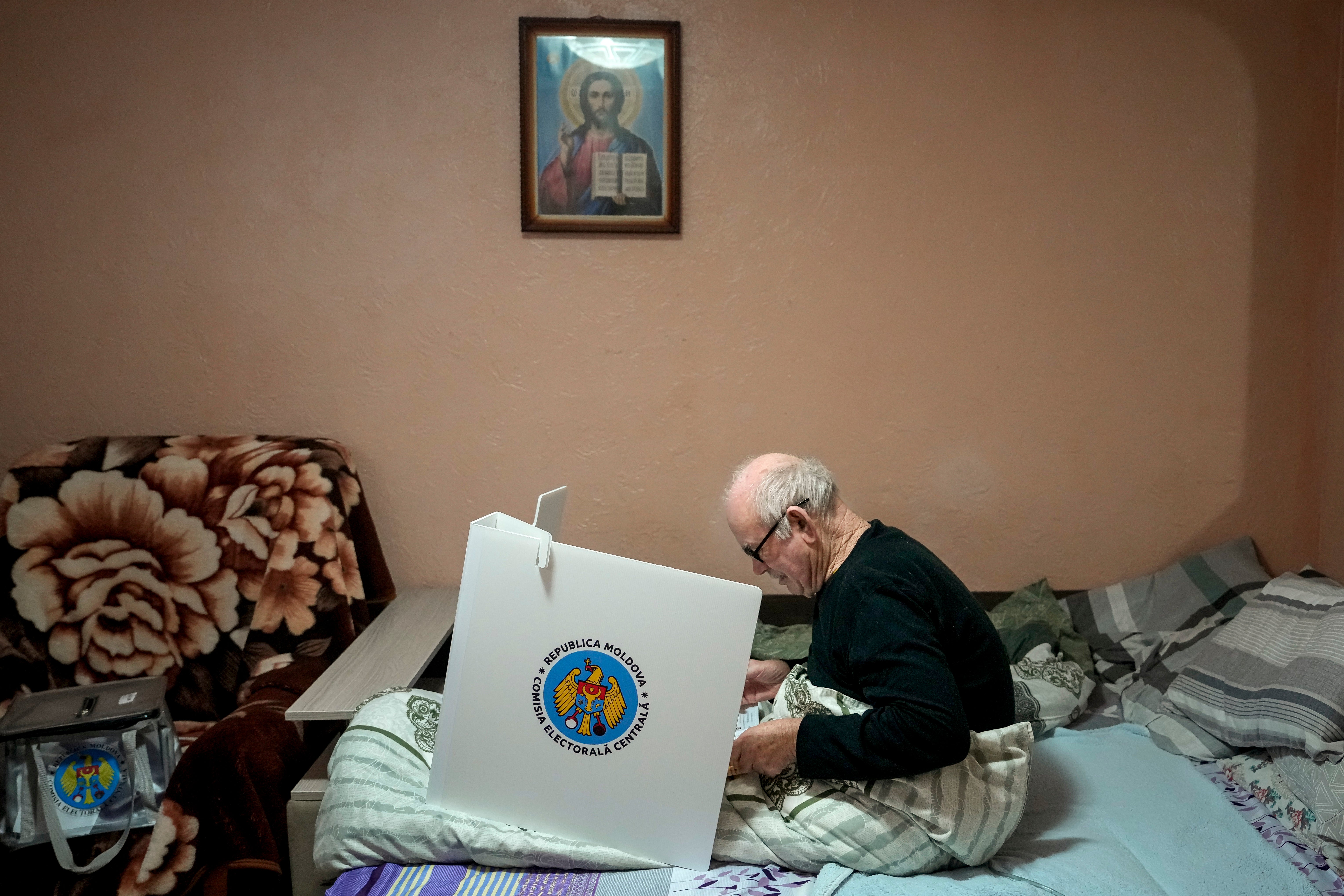 A man casts his vote in a mobile ballot box in the village of Hrusevo, Moldova