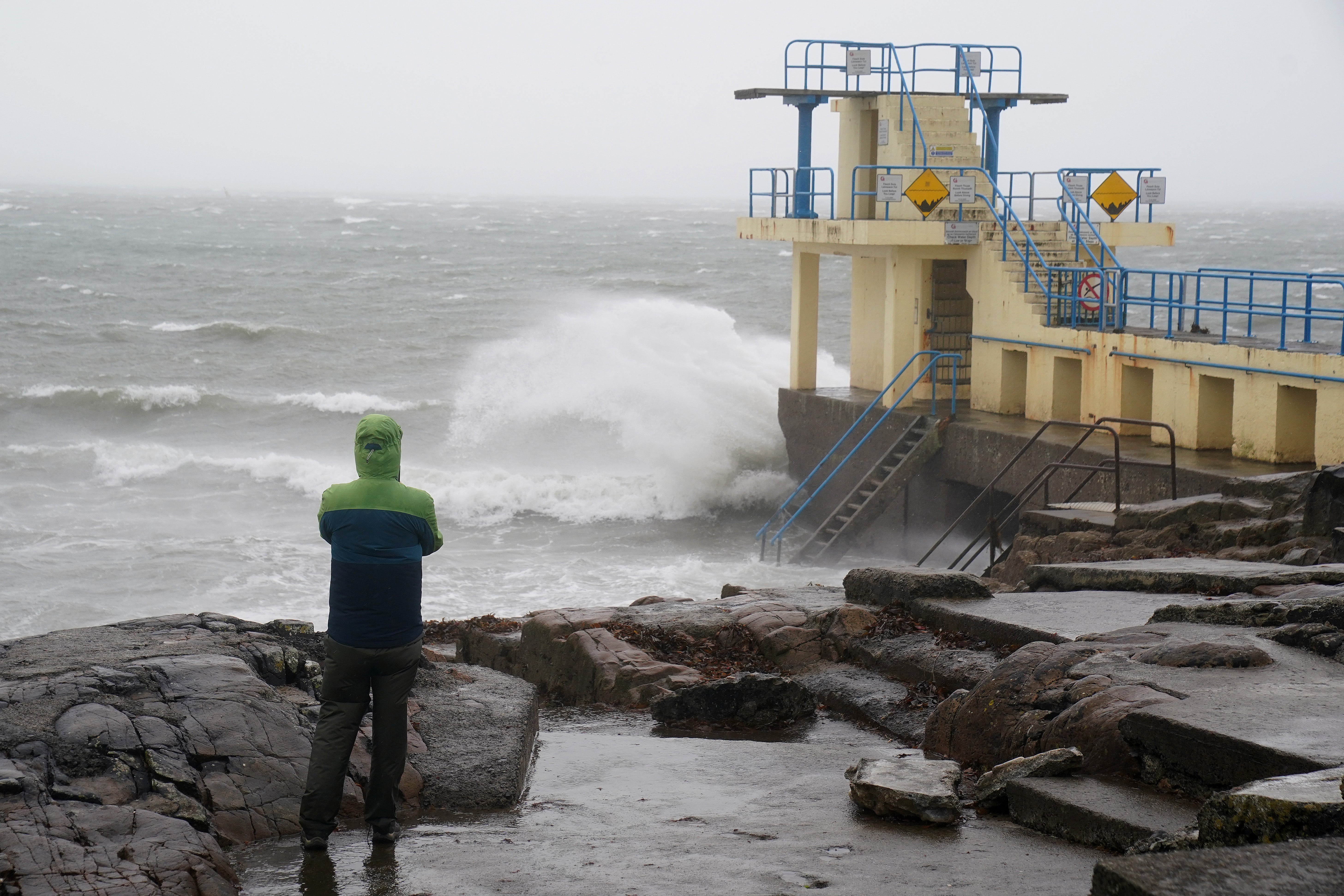 A person watches the waves at the Blackrock diving tower