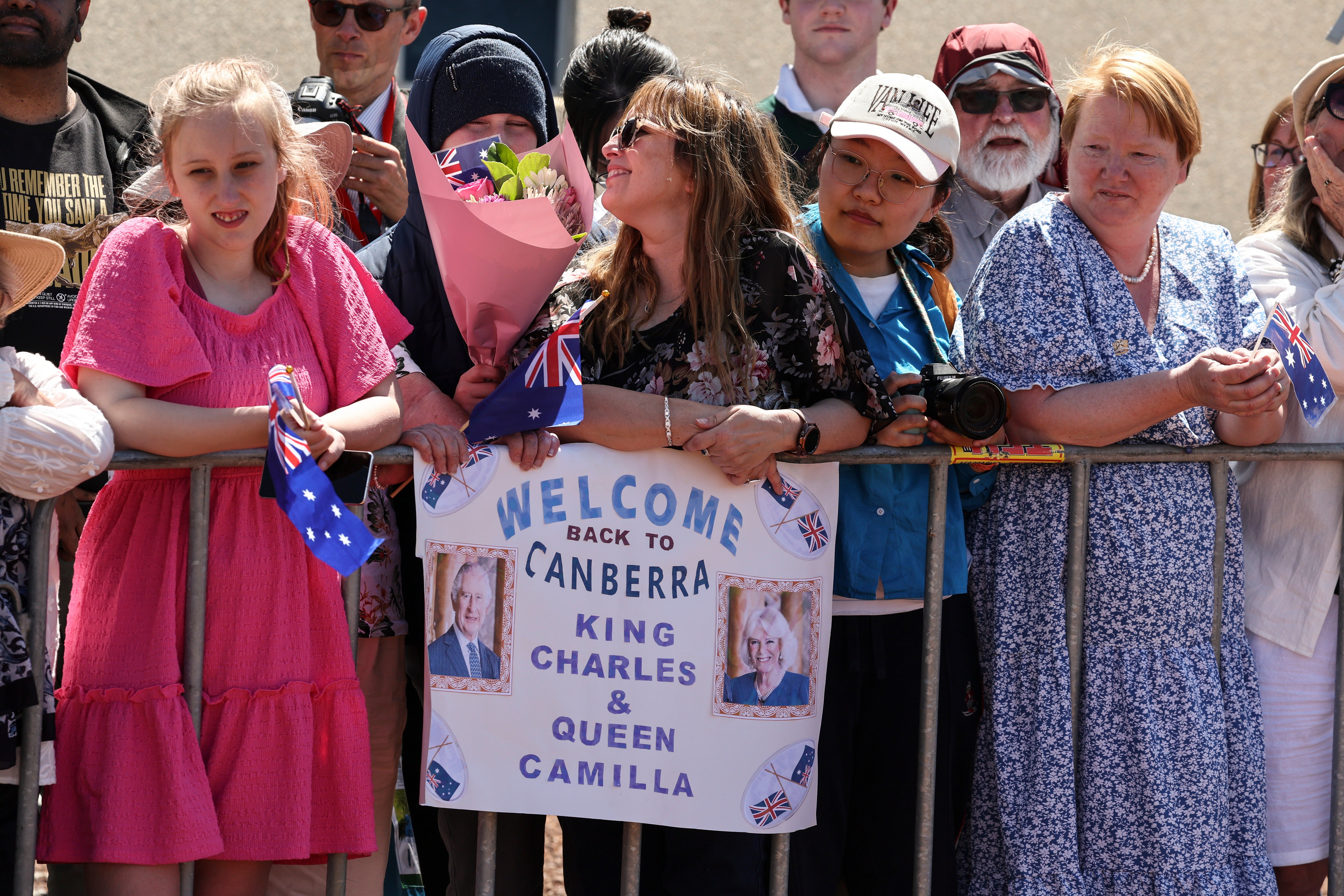 People wait to see Britain's King Charles III and Queen Camilla outside Parliament House.