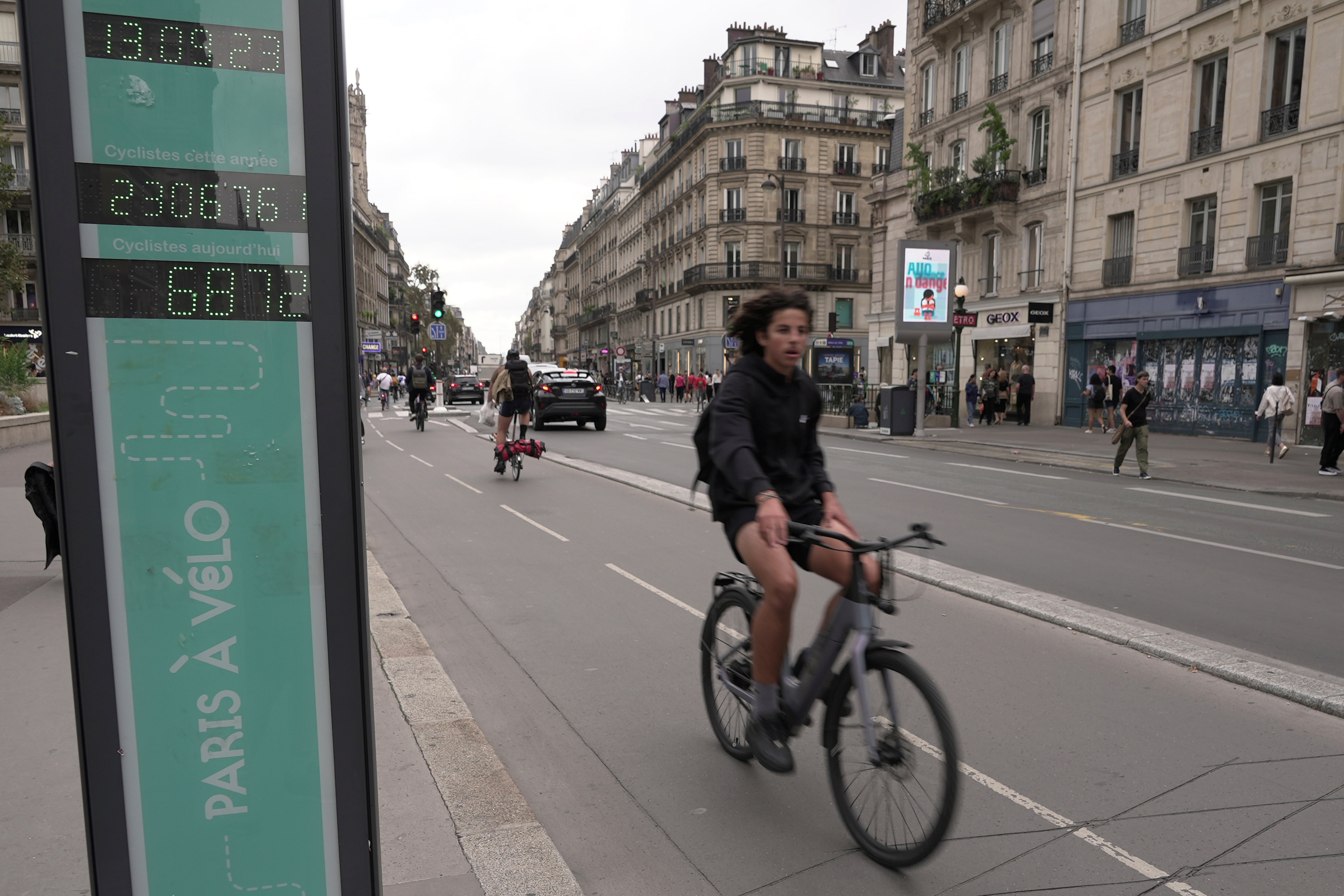 A man rides past a bicycle counter in Paris