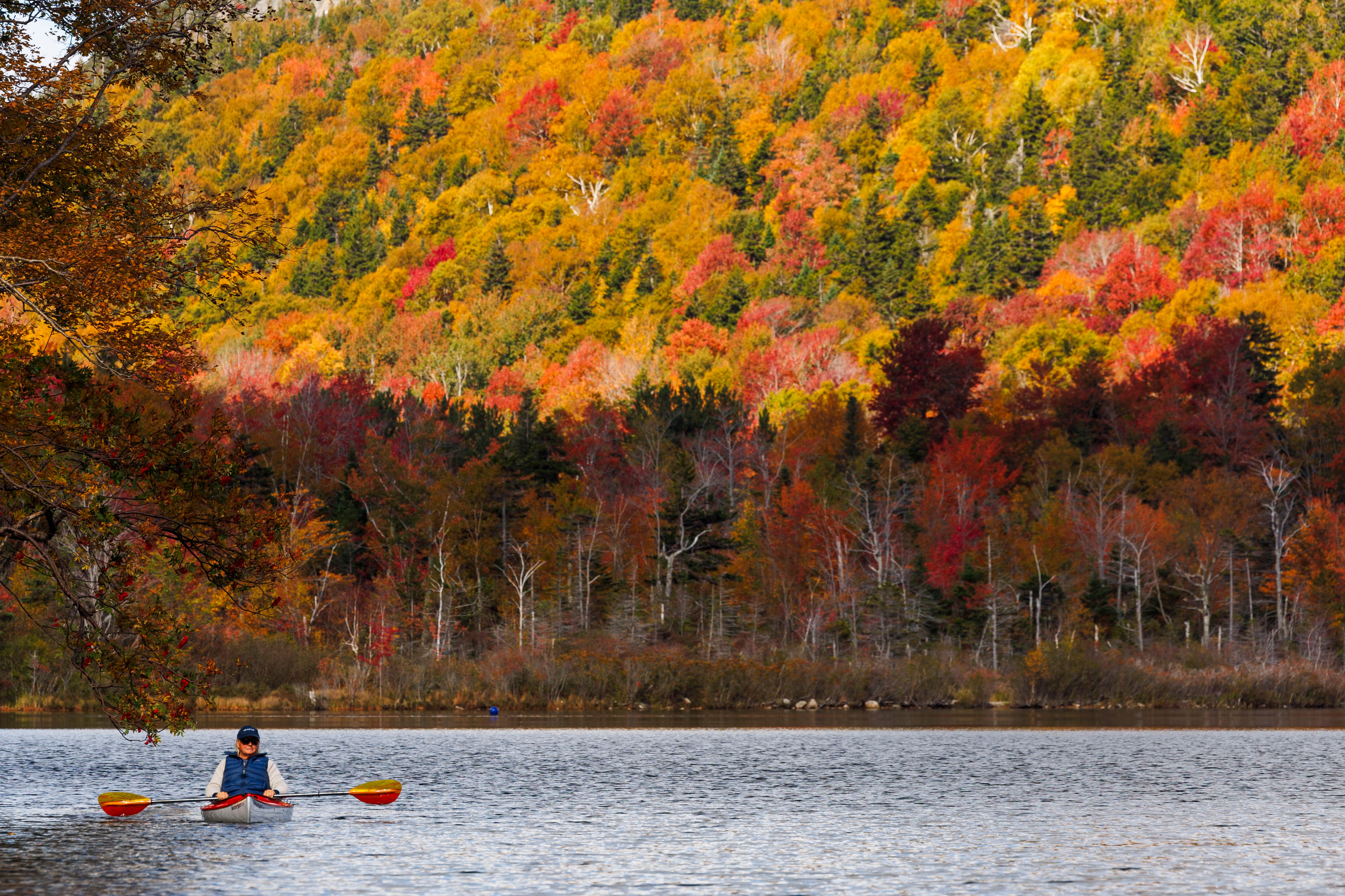 New Hampshire leaves display bright colors near New Hampshire’s Echo Lake earlier this month. Warming temperatures are turning stunning fall foliage displays brown, and pushing back viewing times.