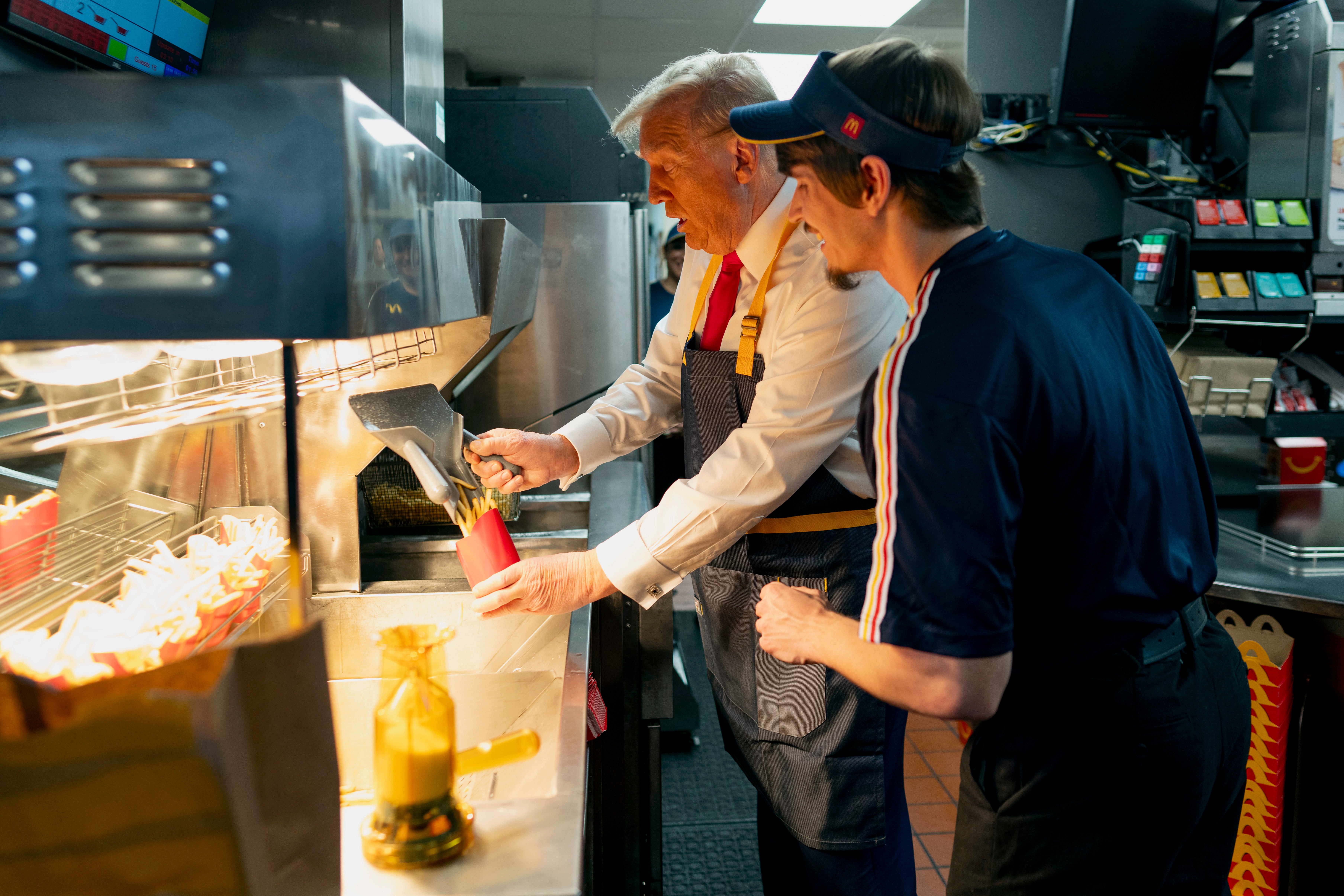 Trump uses fryer next to an employee during his visit to McDonald's in Feasterville-Trevose on Sunday