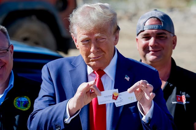 <p>Former  president and Republican presidential nominee Donald Trump holds an official McDonald’s fries cook pin given to him during a tour of Hurricane Helene’s devastation on October 21 </p>