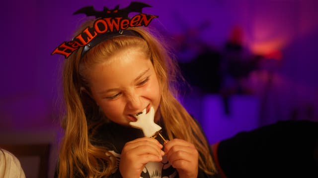 <p>A young girl eats a chocolate ghost on Halloween. Chocolate prices are going up this year amid a shortage of its main ingredient, cocoa beans.  </p>