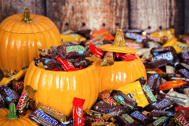 Dallas, United States - October 31, 2015: Decorative pumpkins filled with assorted Halloween chocolate candy made by Mars, Incorporated and the Hershey Company.