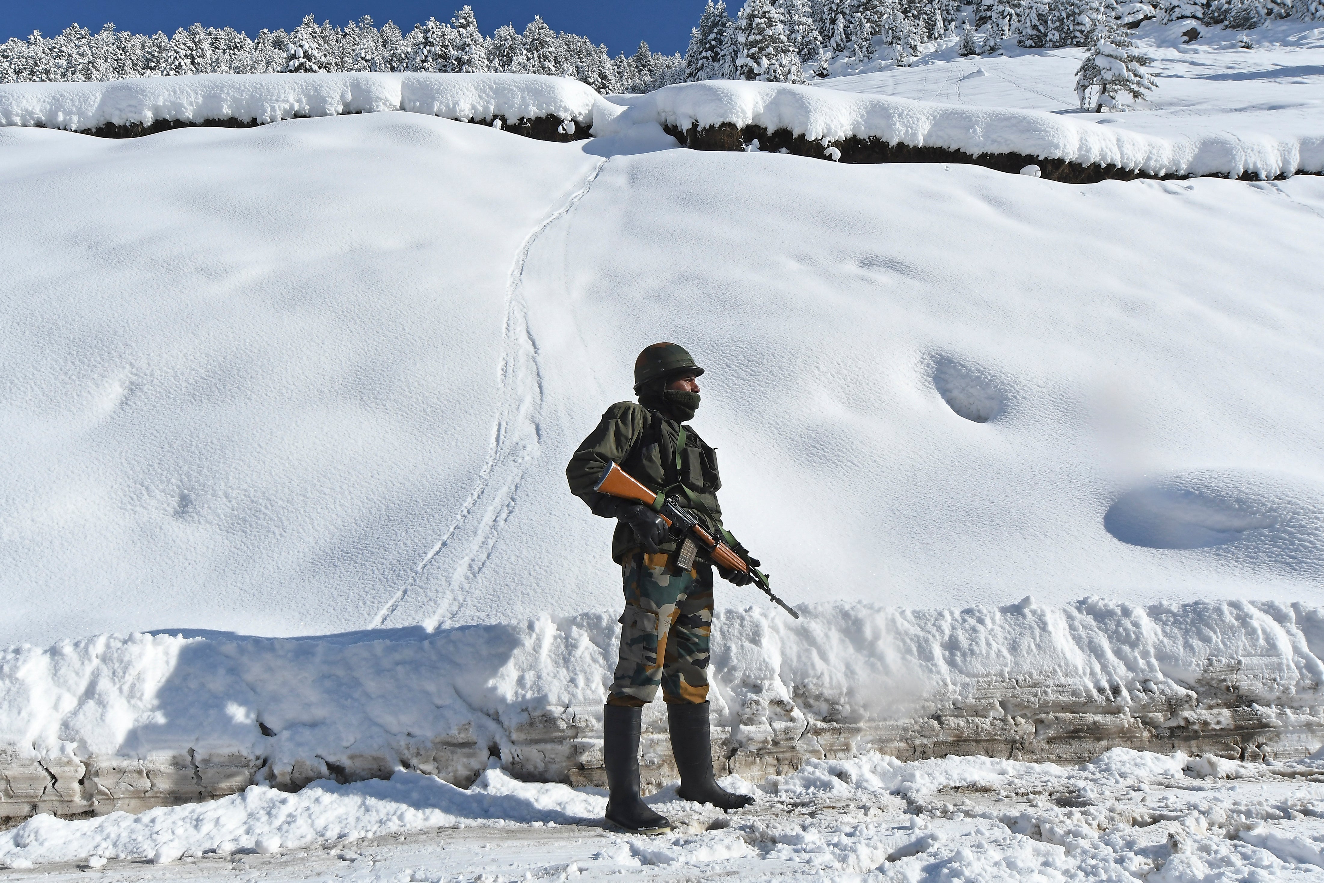 An Indian worker  stands connected  a roadworthy  adjacent   Zojila upland  walk  that connects the restive Himalayan vale  of Kashmir to the national  territory   of Ladakh bordering China connected  28 February 2021