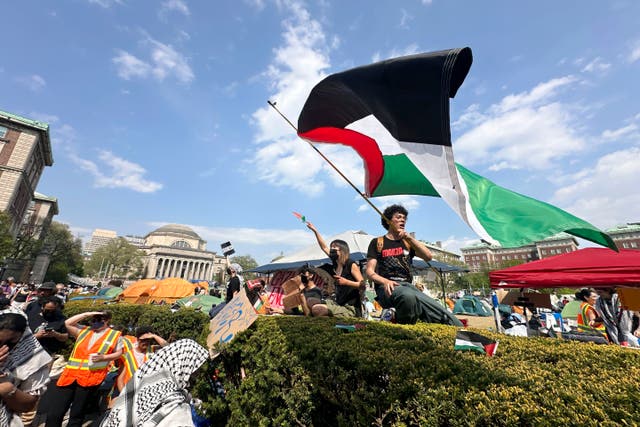 <p>A demonstrator waves a flag on the Columbia University campus at a pro-Palestinian protest encampment</p>