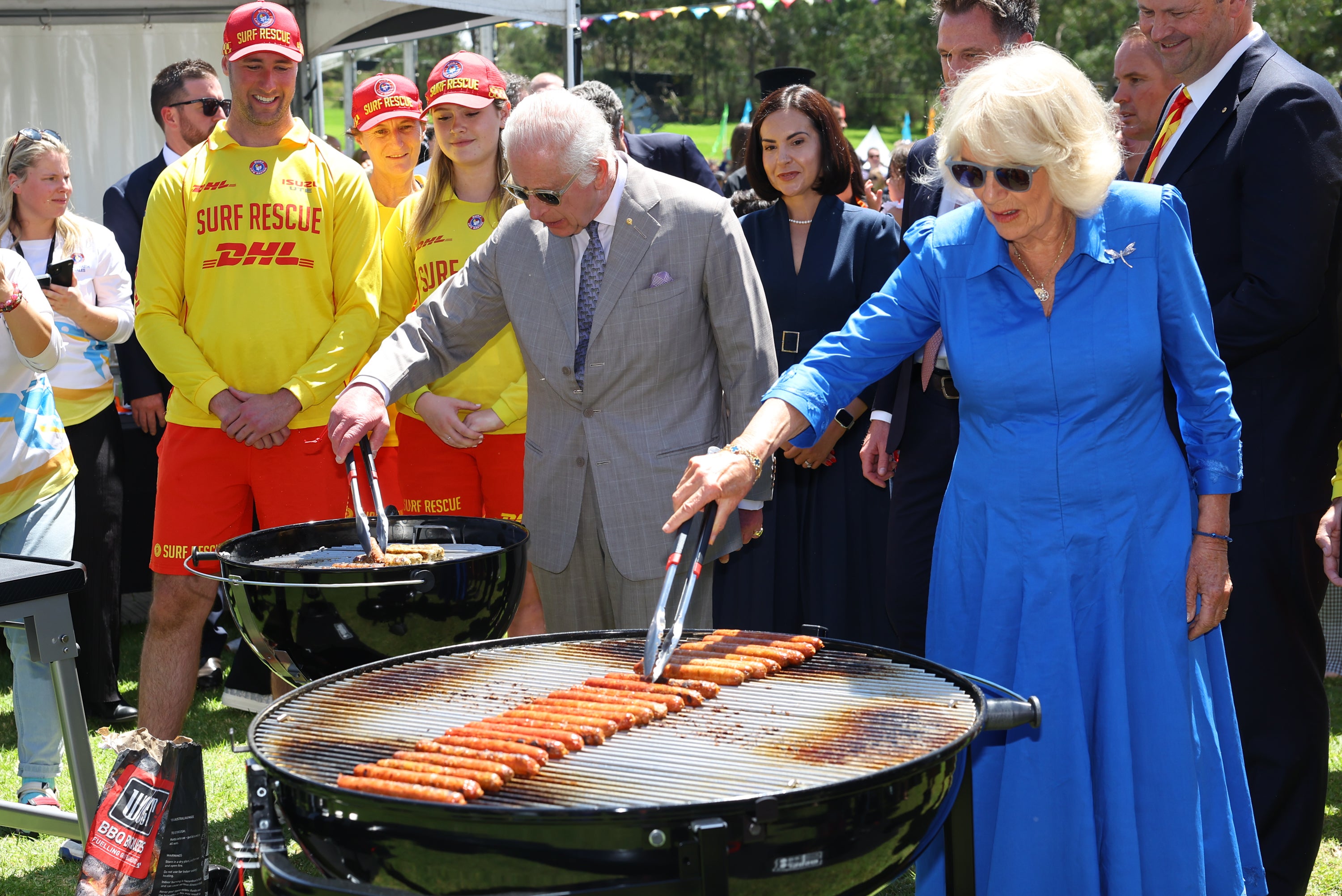 King Charles and Queen Camilla help cook sausages during a community barbeque hosted by the Premier of New South Wales Chris Minns at Parramatta Park in Sydney